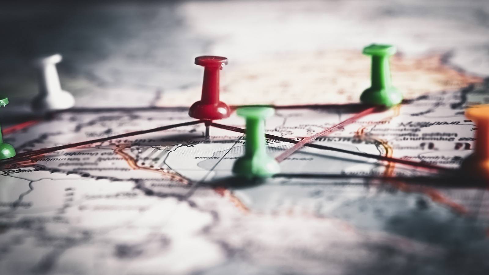 map with thumbtacks marking cities