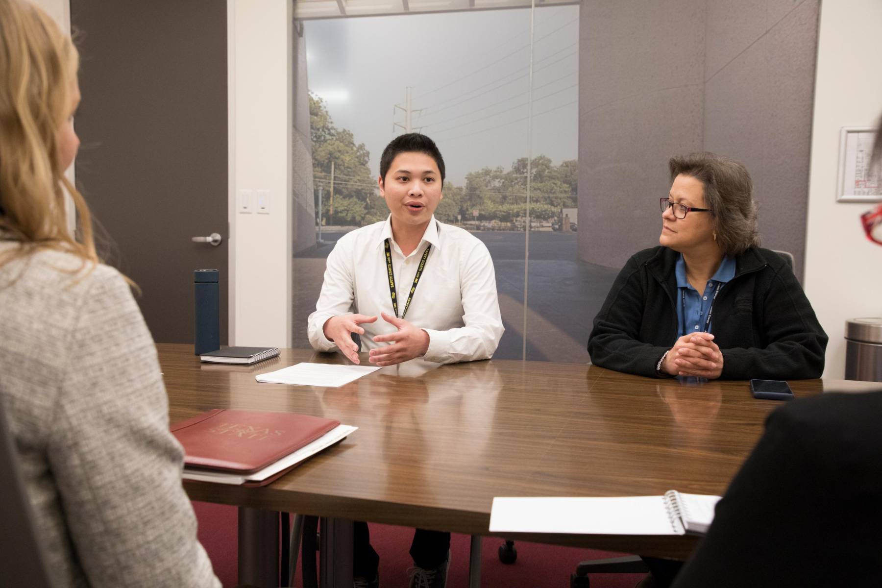 students sitting in a classroom discussing over textbooks