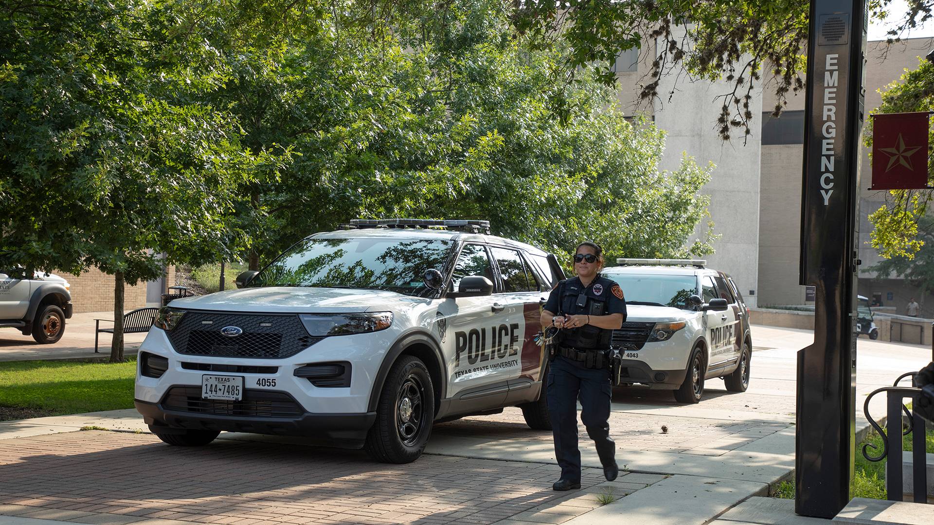 a police officer walking past a police car