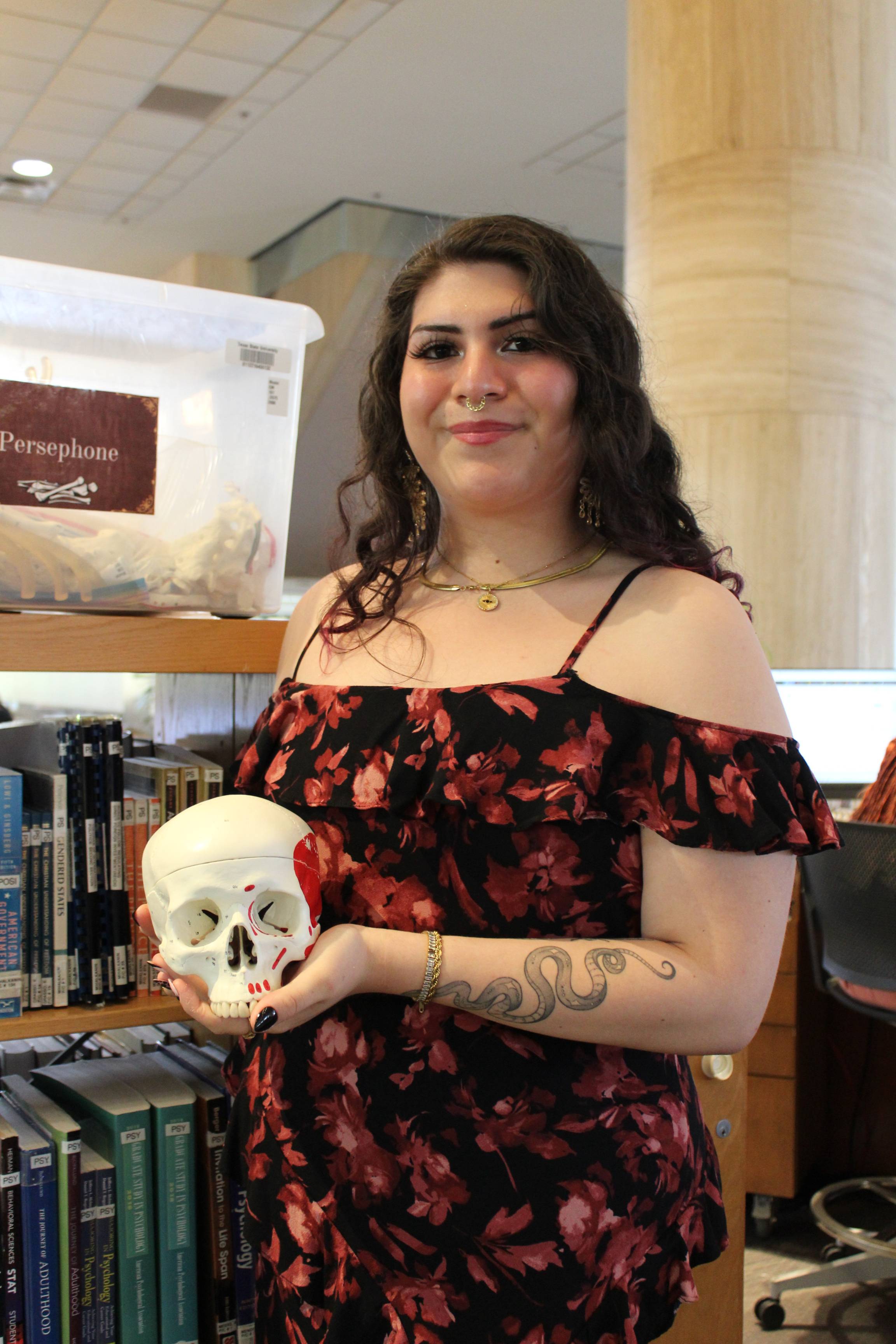 A female student holding a skeletal brain structure.