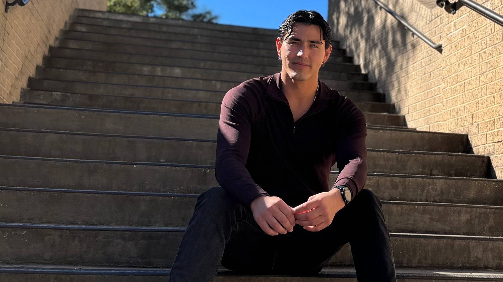 Yeremi Hykel sitting on the steps of McCoy Hall
