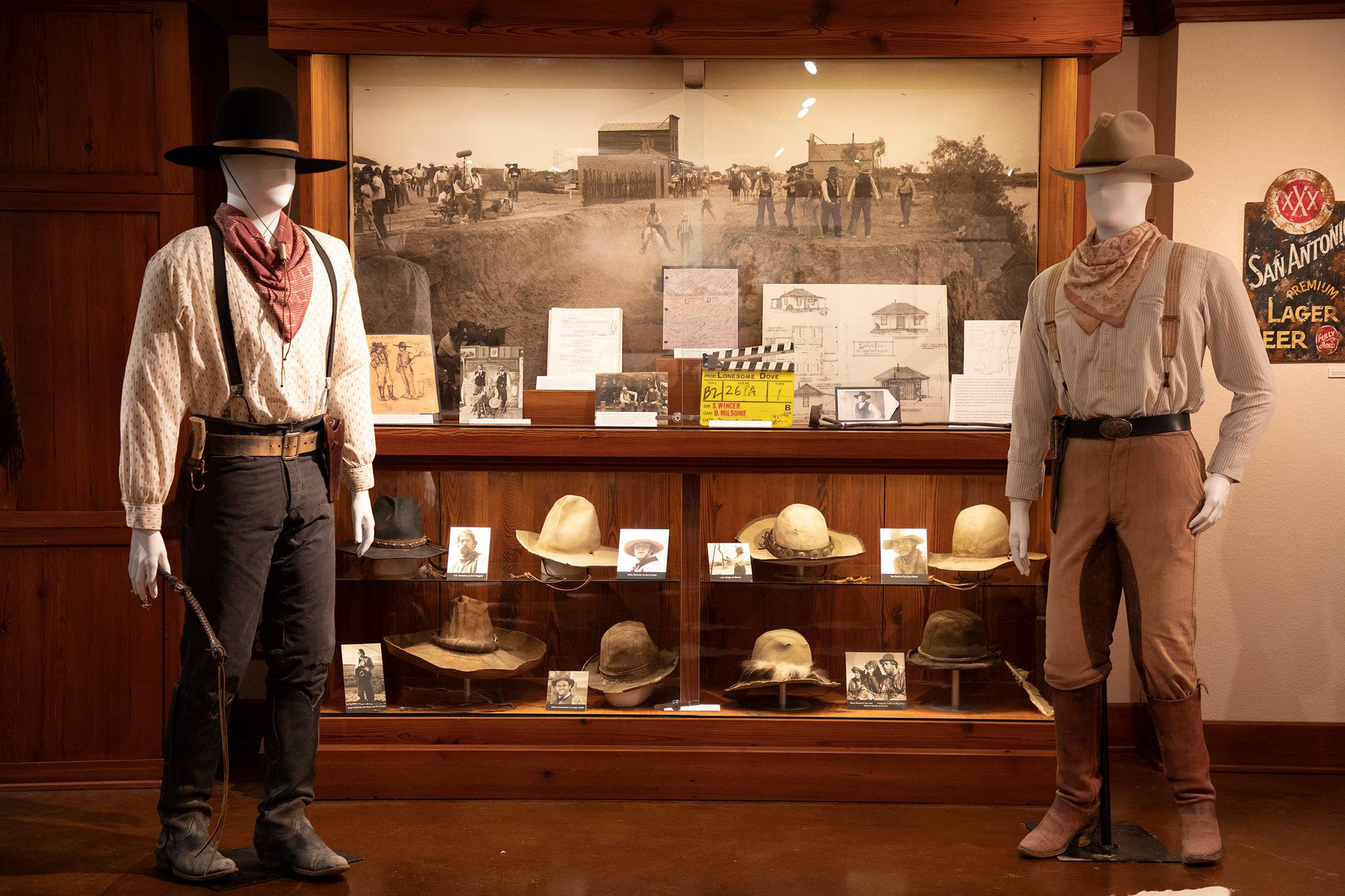 cowboy hats in a glass display at a museum
