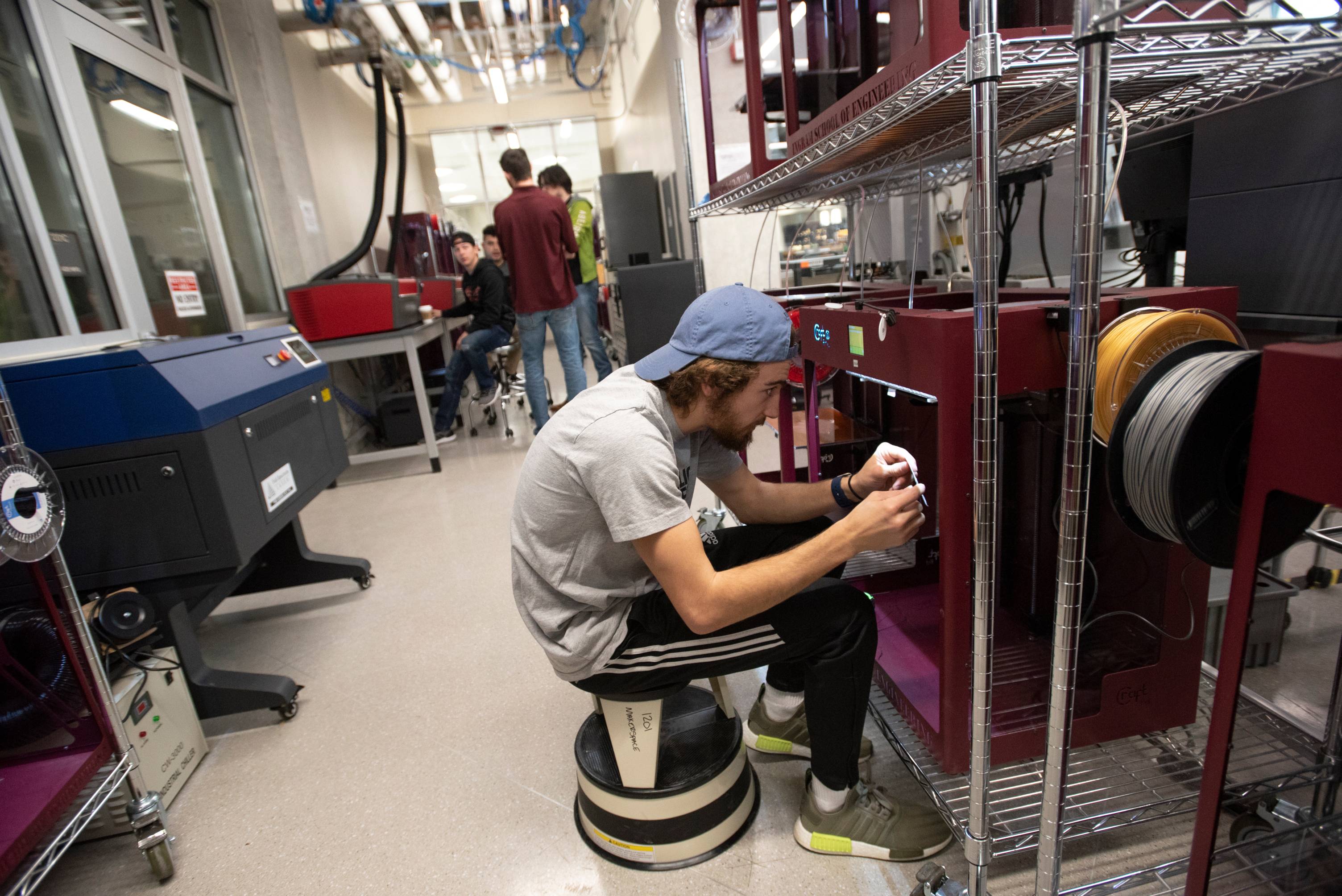Student working at a fabrication machine in the Makerspace