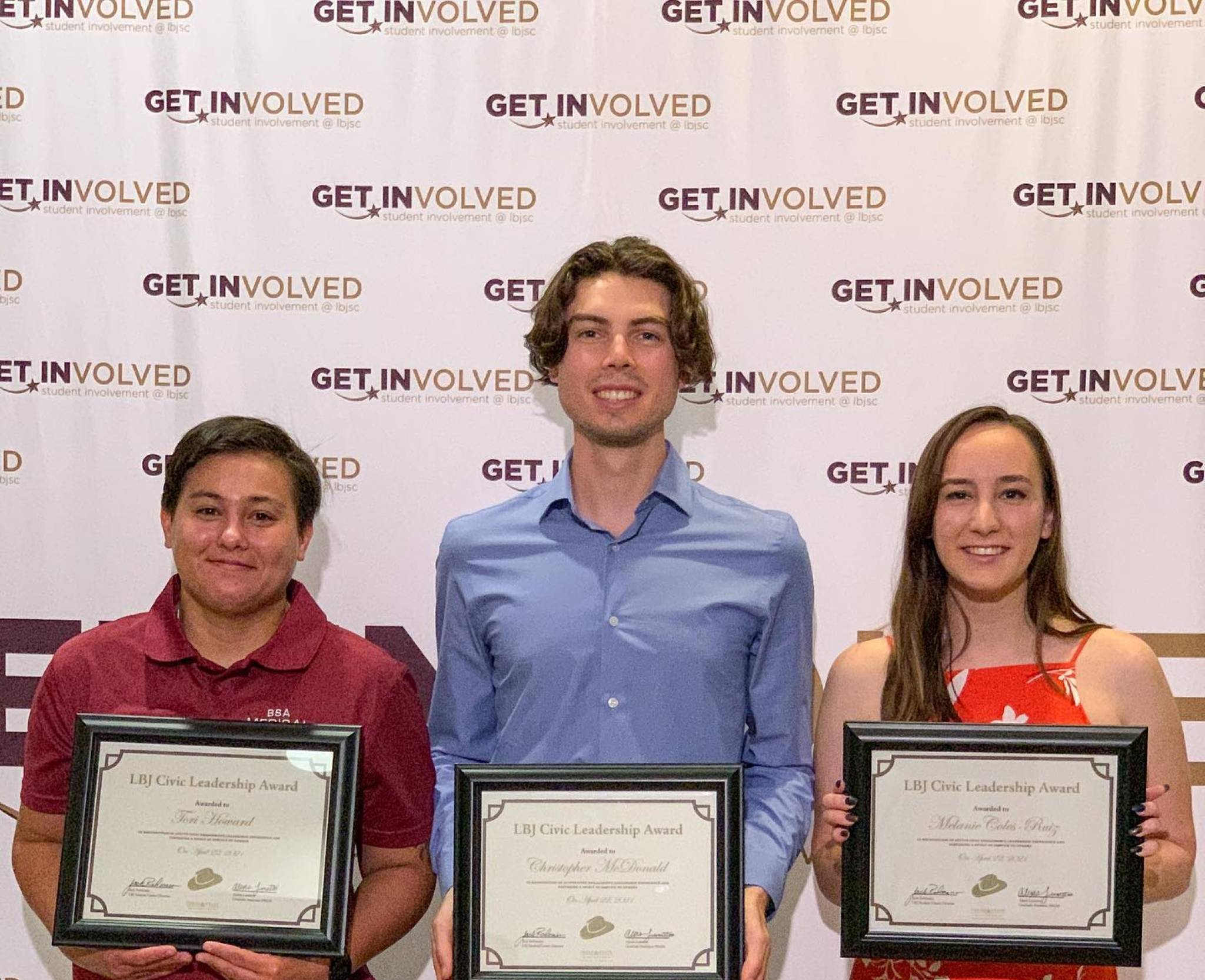 three people posing for photo while each holding certificate