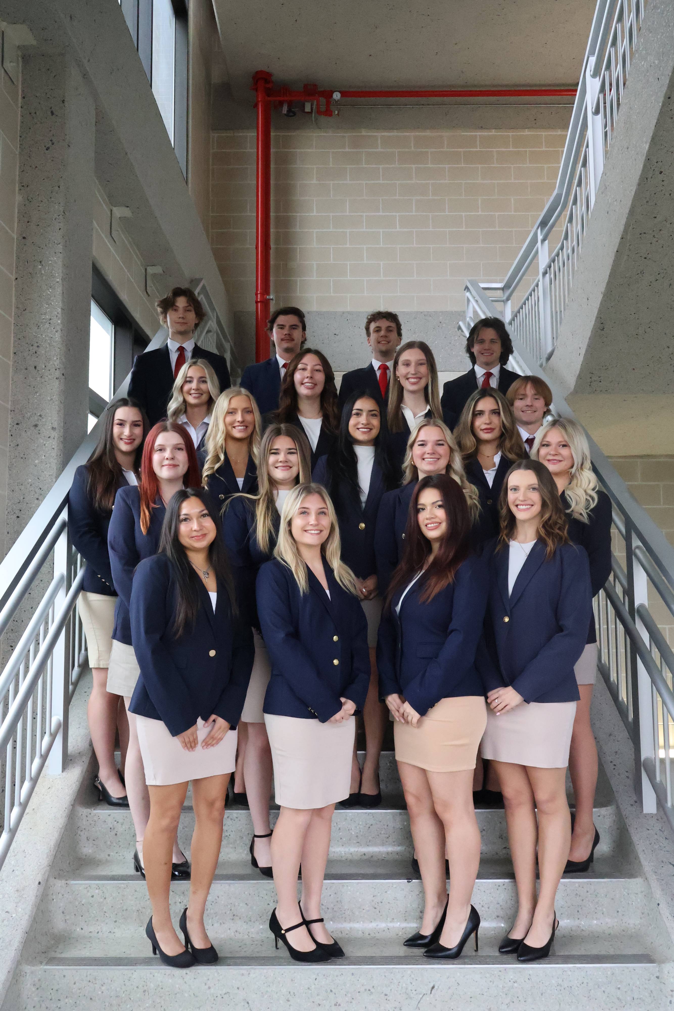 students in business professional smiling for a photo