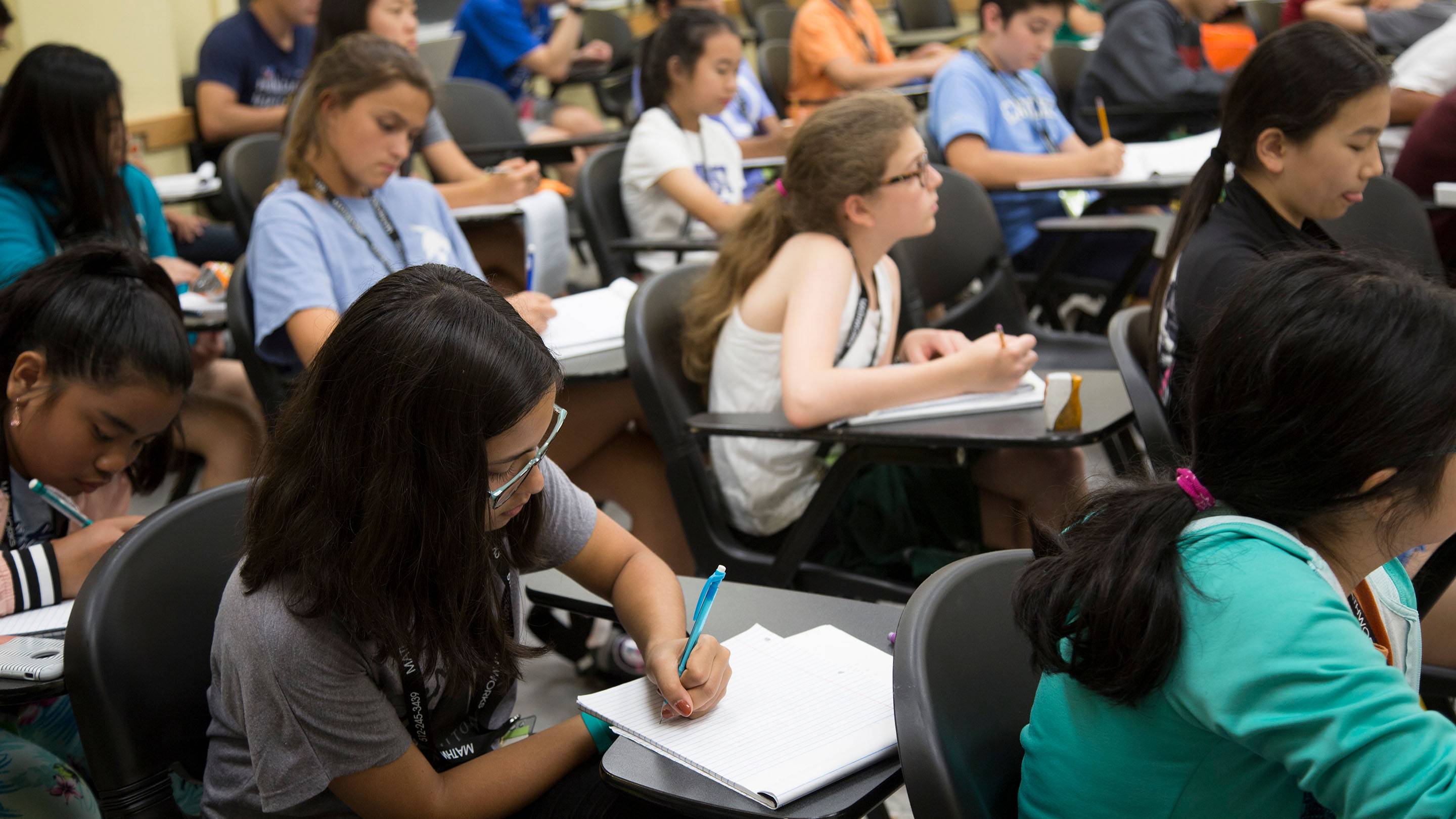 Students take notes in a classroom.