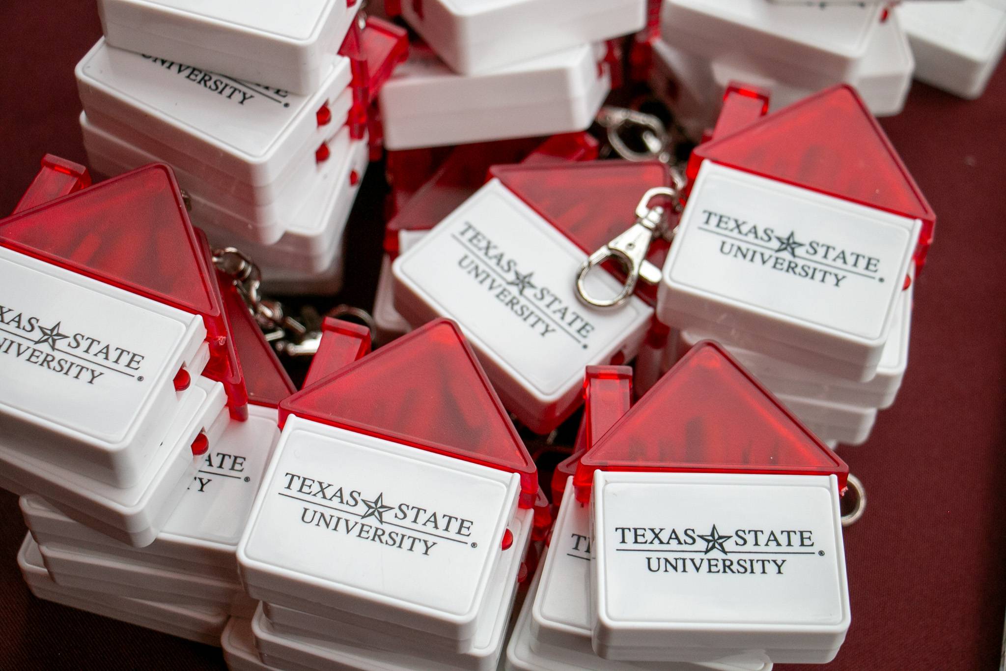 promotional items on a table. Houses that say "Texas State University"