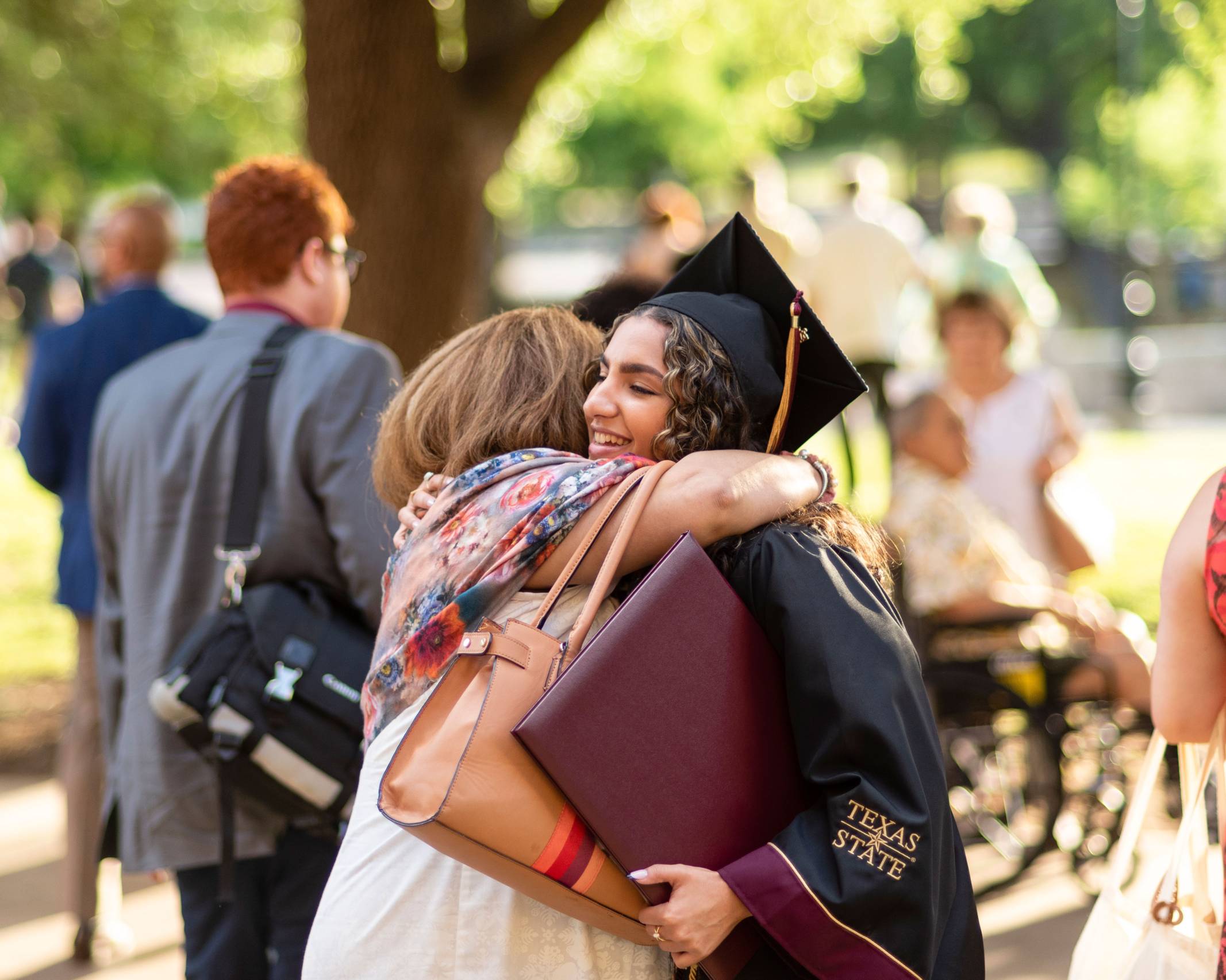A graduate hugs a guest