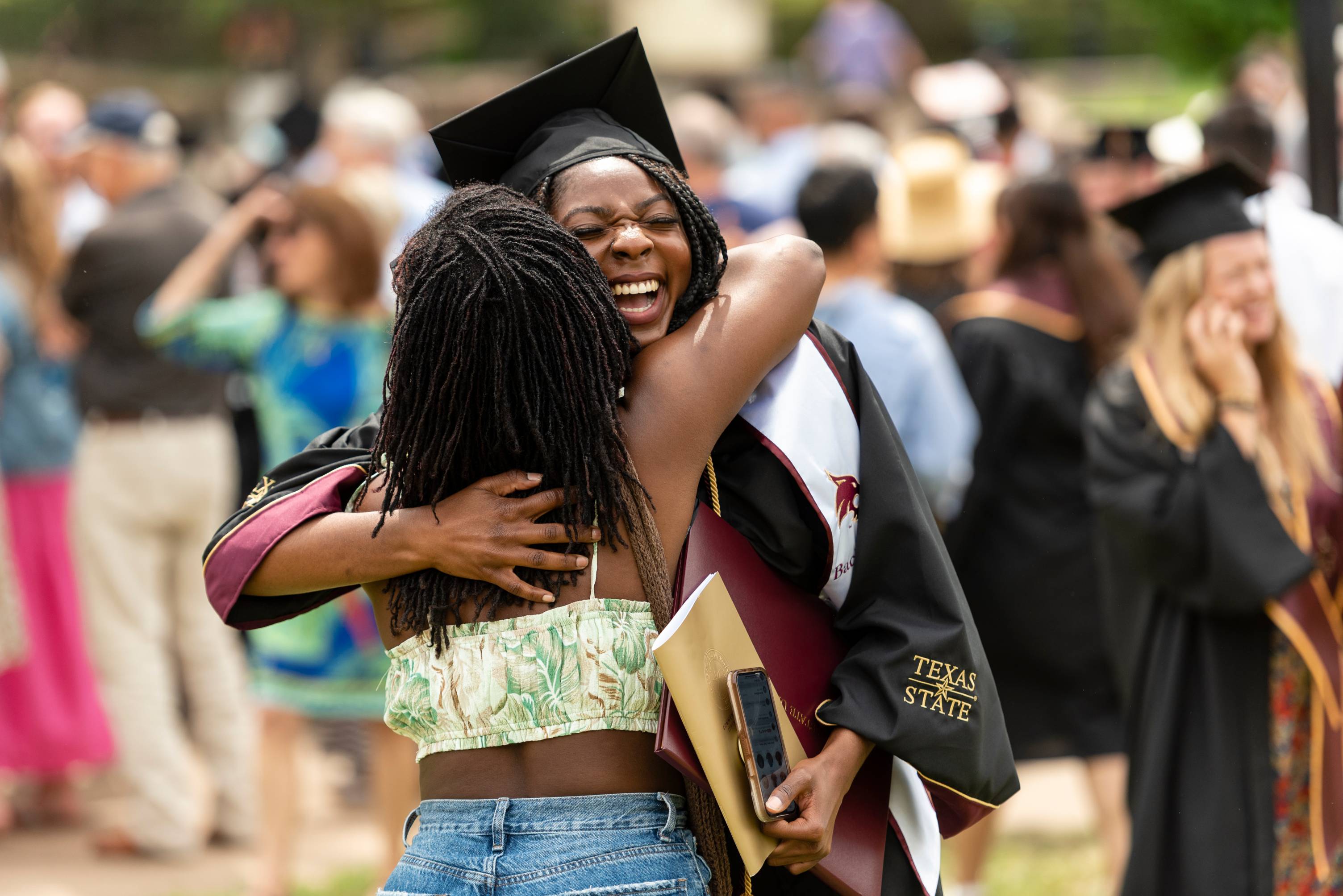 Friends hugging at TXST graduation