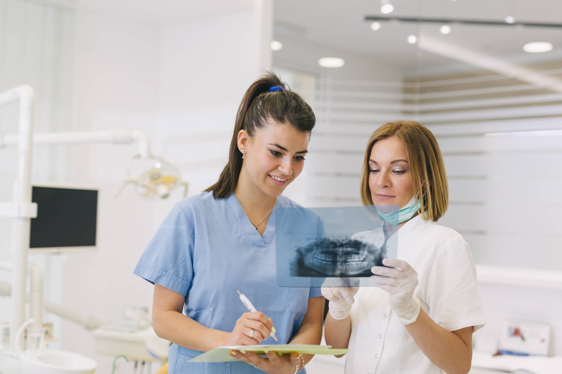 a dentist and assistant looking at an xray