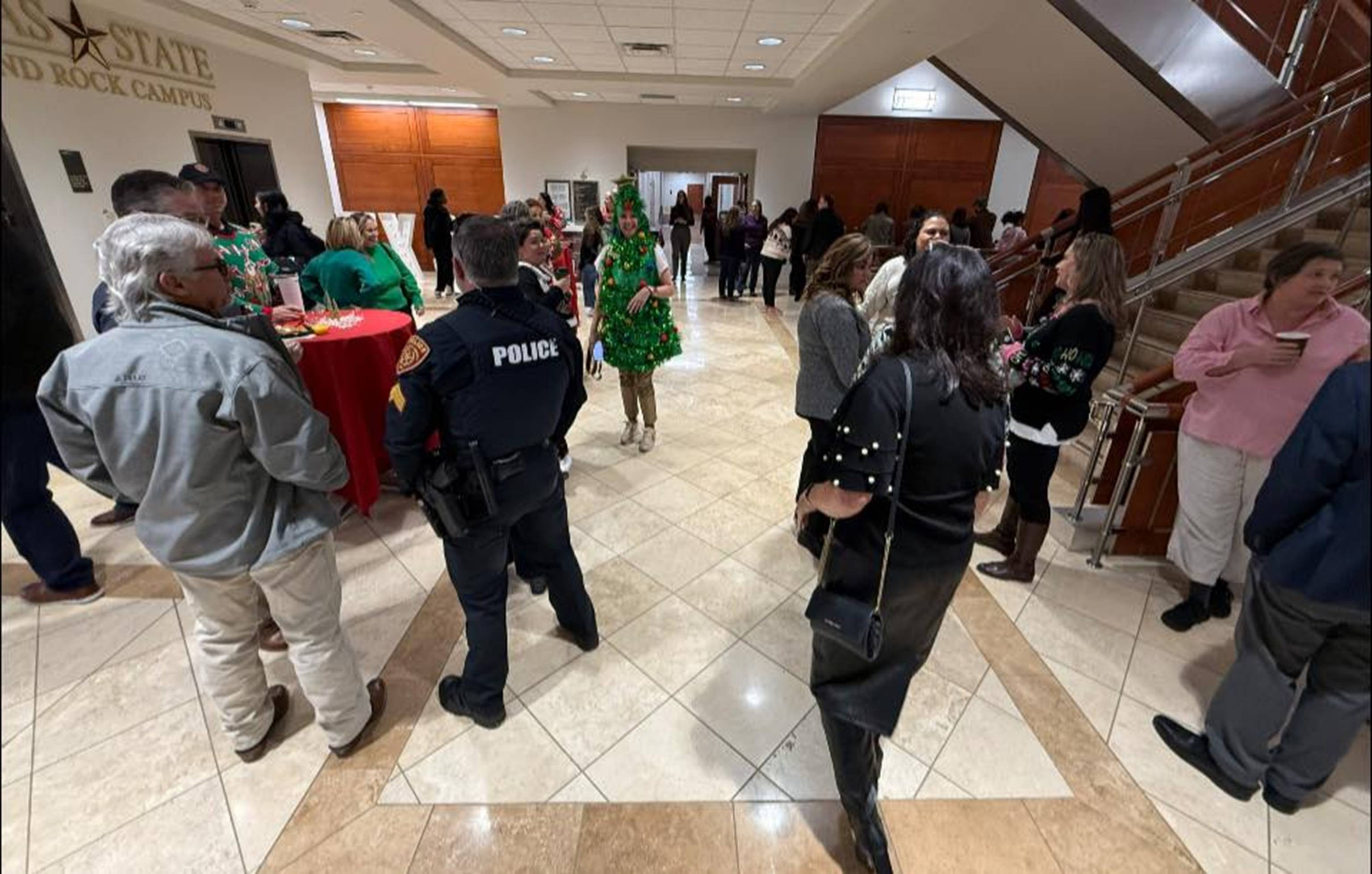 A group of people chatting by the staircase.