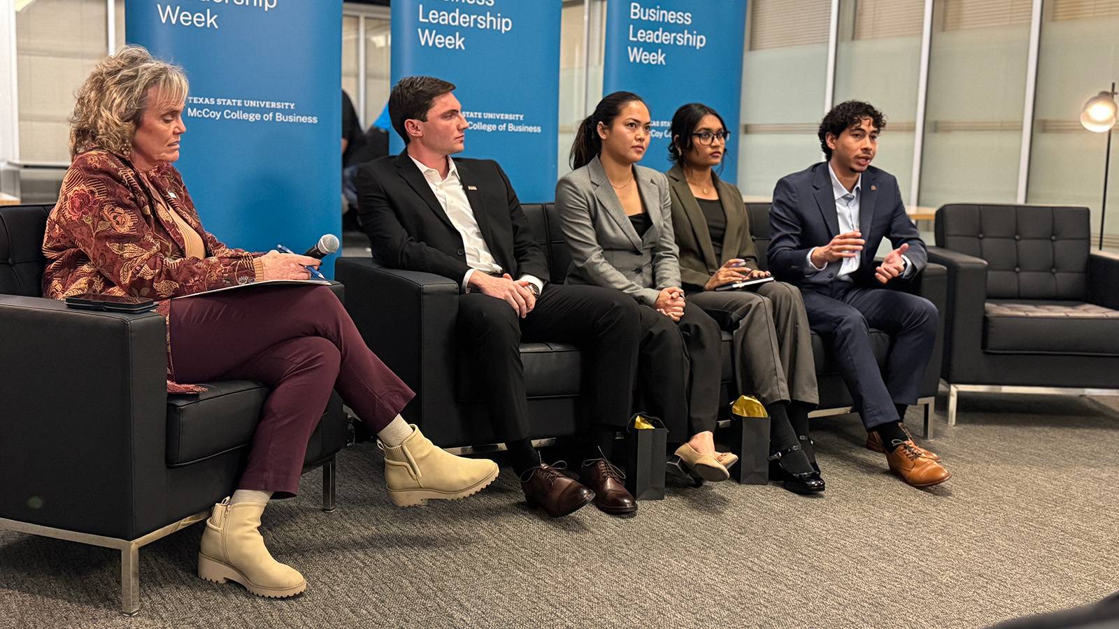 four student speakers sitting on a couch during a panel session as an older women moderates