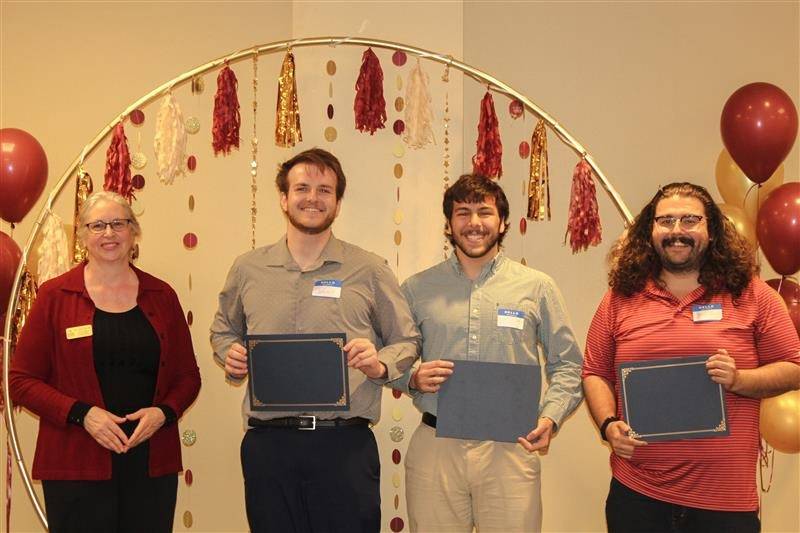 library directory handing out certificates to first place winner team Ingram Ironman