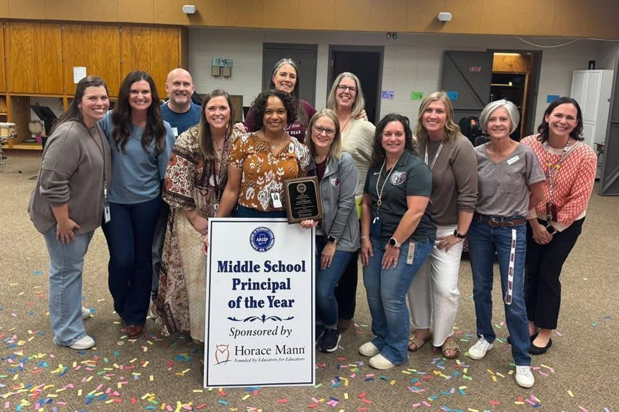 Heather with her principal of the year award surrounded by colleagues