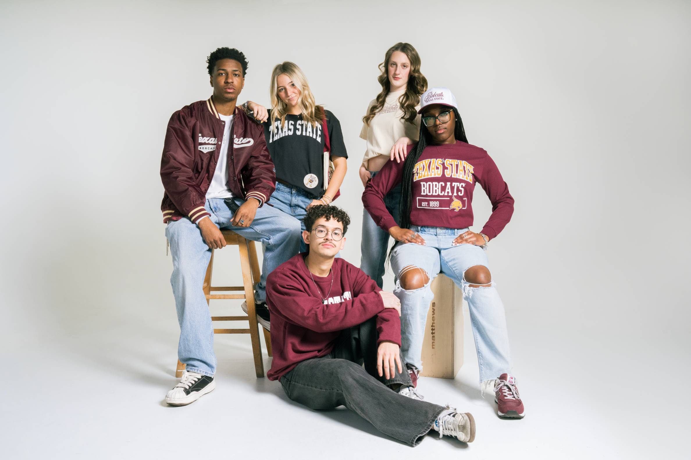 5 student influencers posing in studio wearing TXST swag