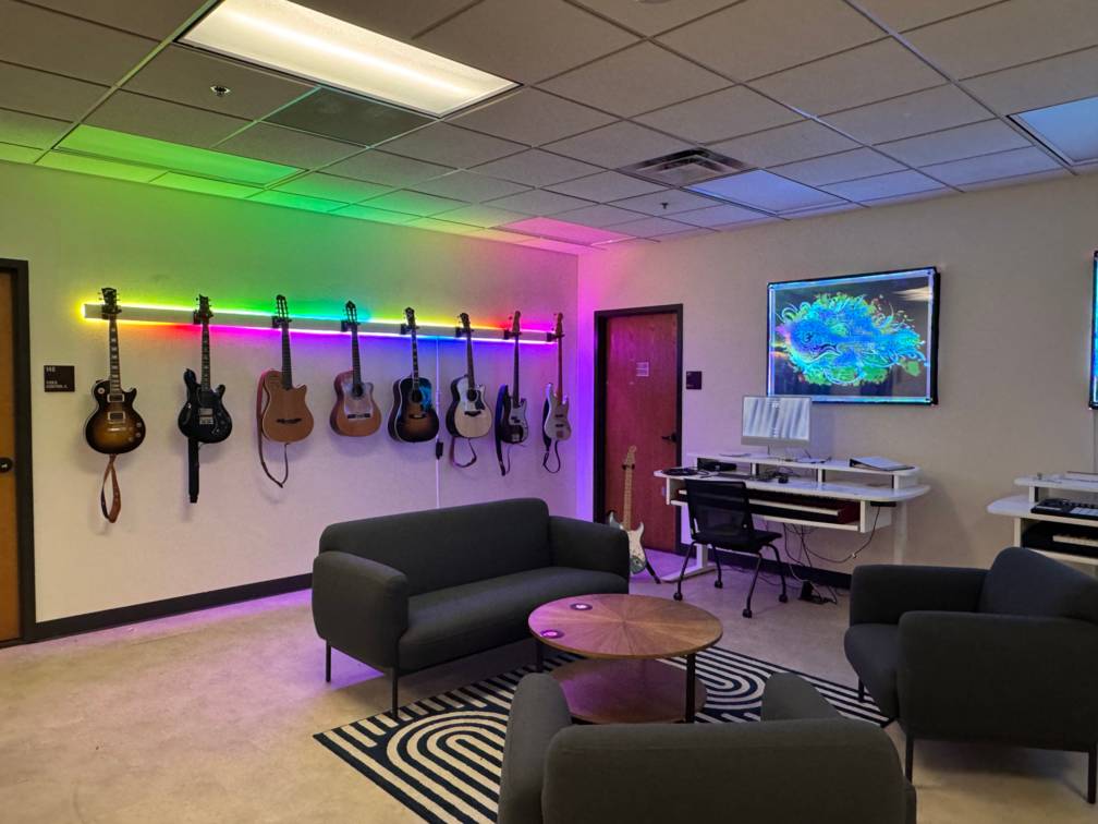 A room with guitars hanged to the wall and space to sit, record music