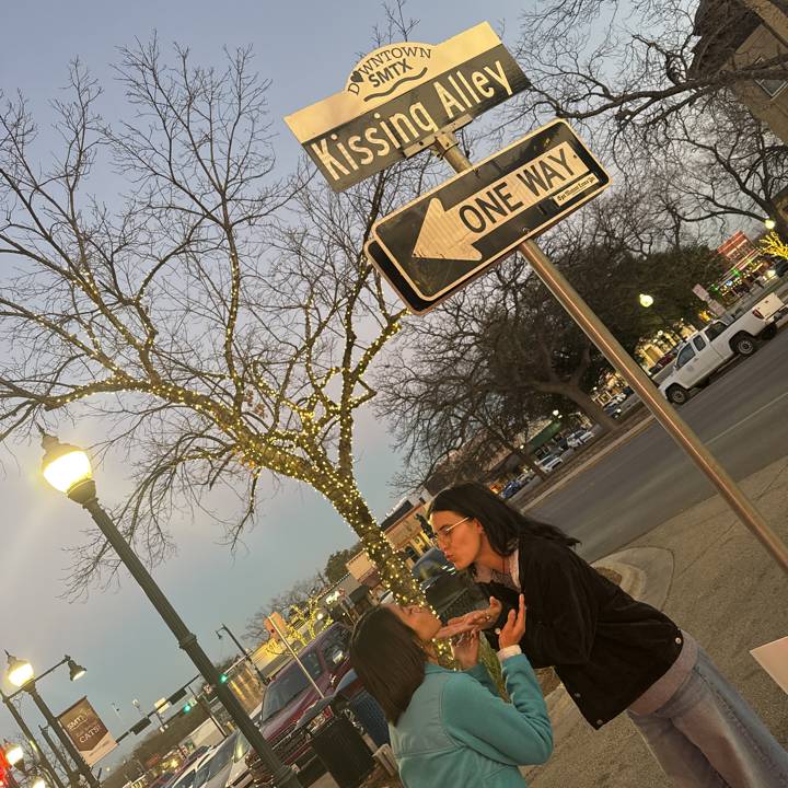 Two girls standing next to sign
