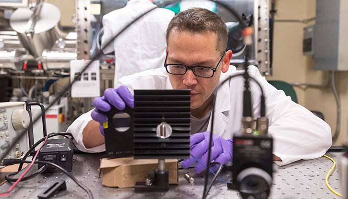 physics instructor examining equipment in a laboratory