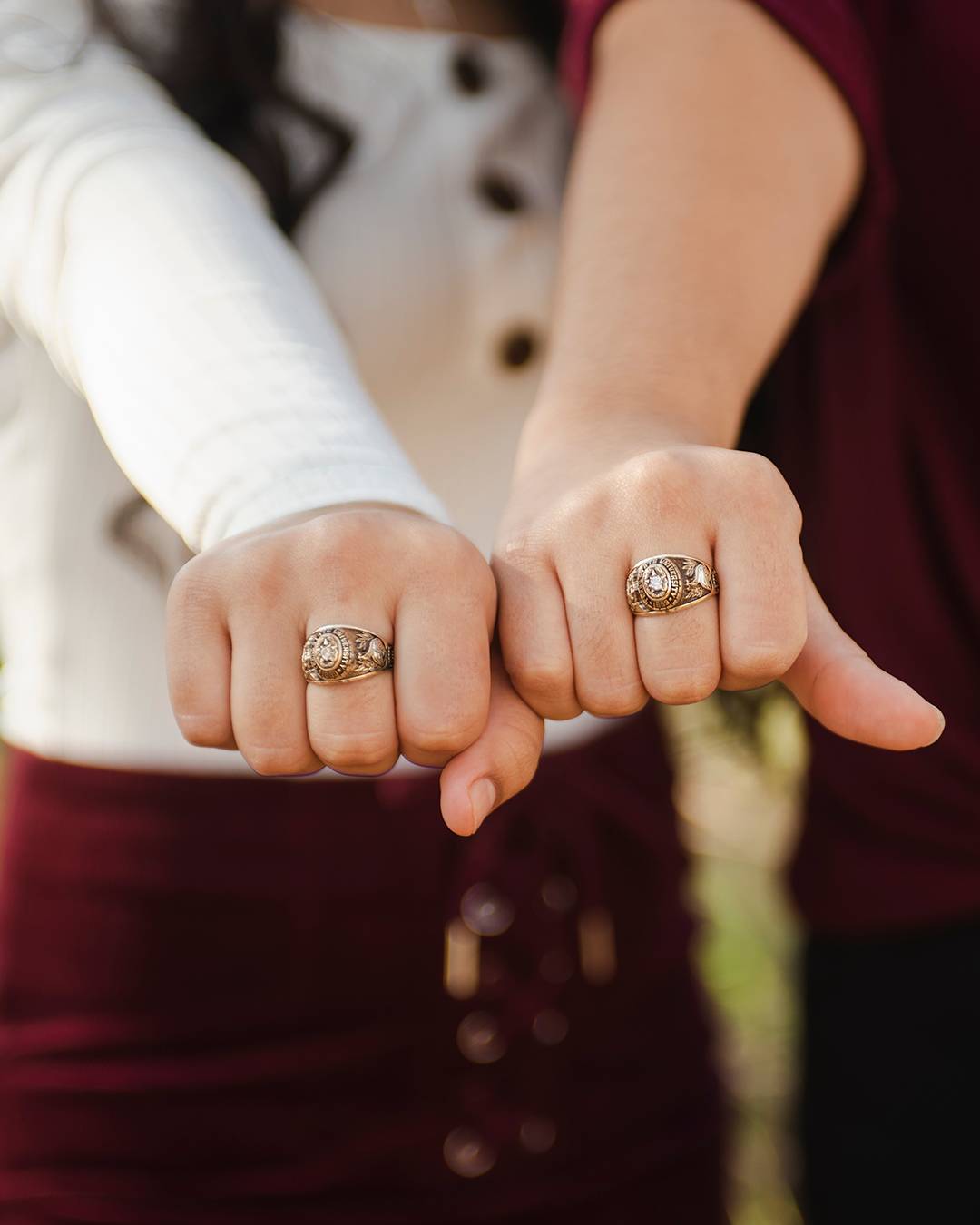 Two official Texas State class rings on two different hands