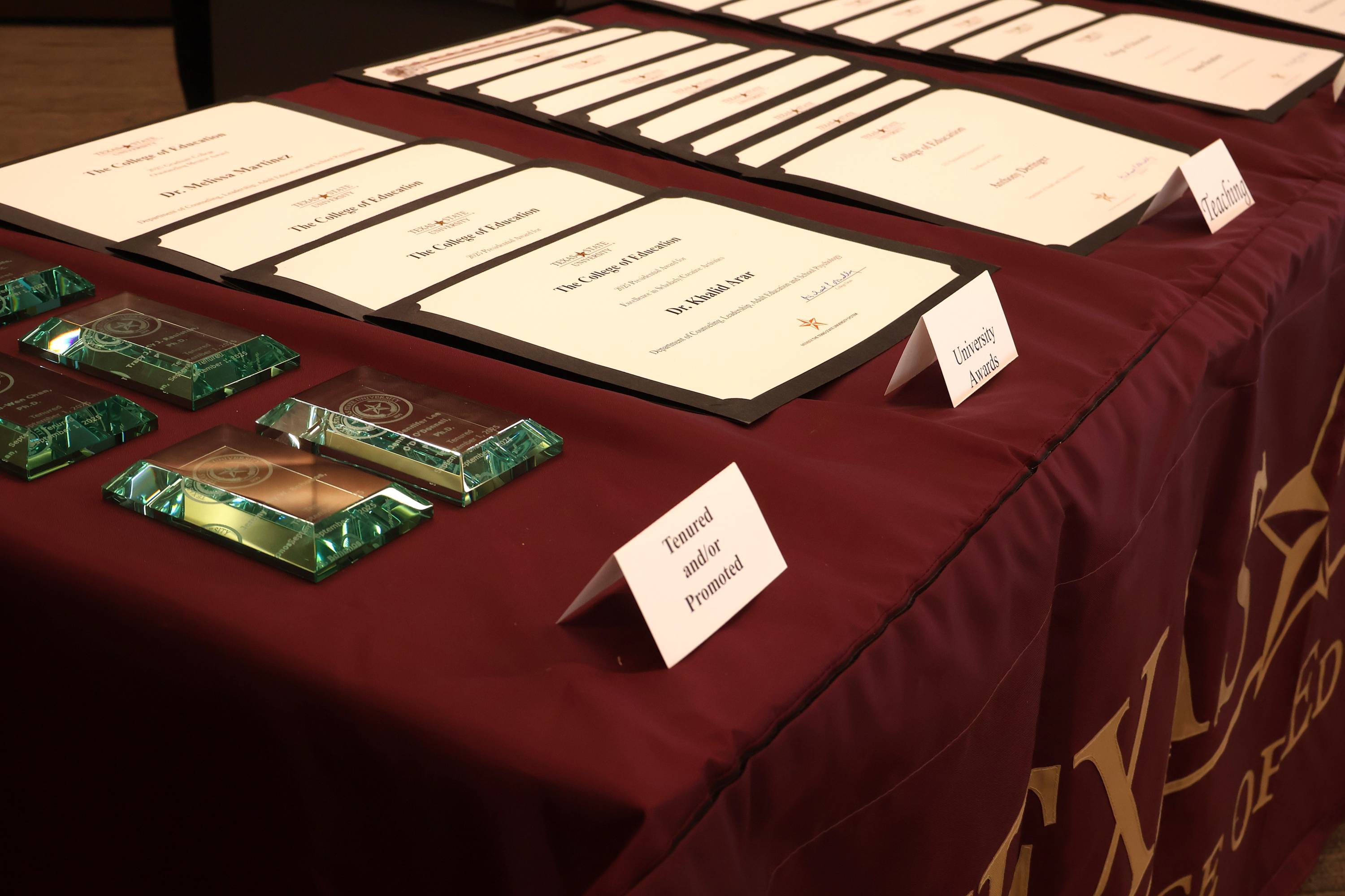 certificates and glass awards displayed on table