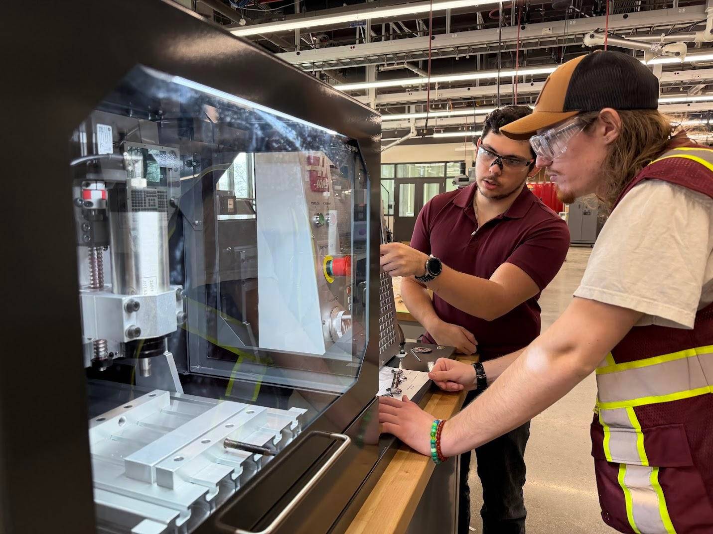 Two students working on a new Haas desktop mill