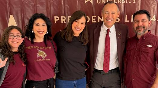 President Kelly Damphousse (middle right) poses for a photo with a a student and her family.