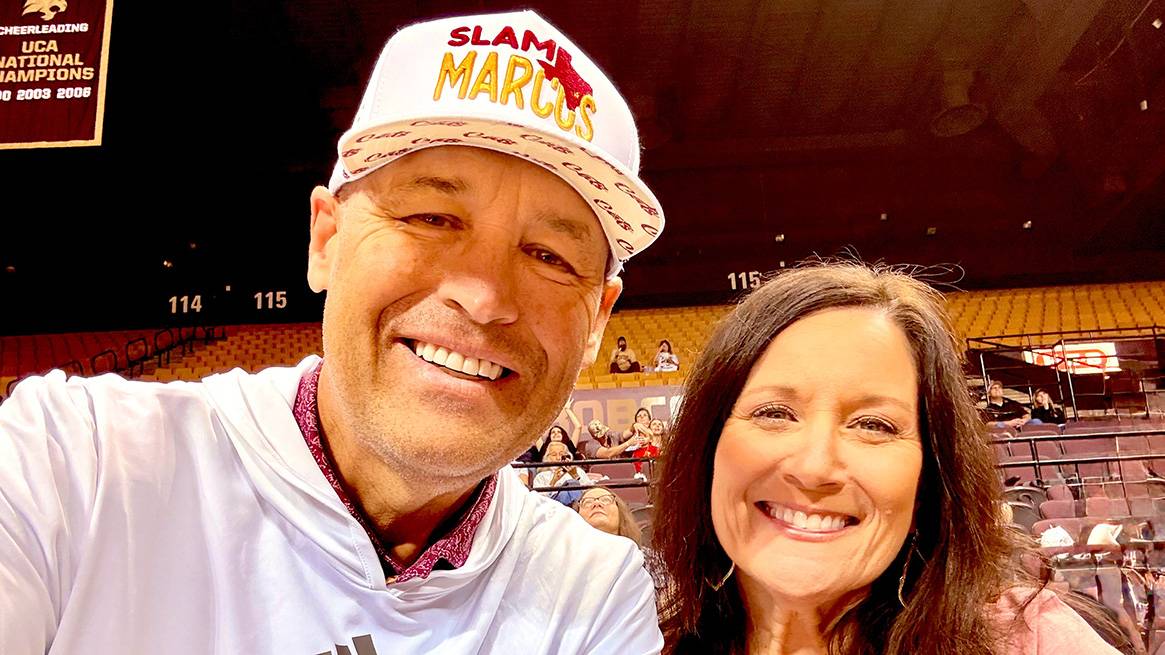 President Damphousse (left) poses for a photo with First Lady Beth Damphousse at a basketball game.