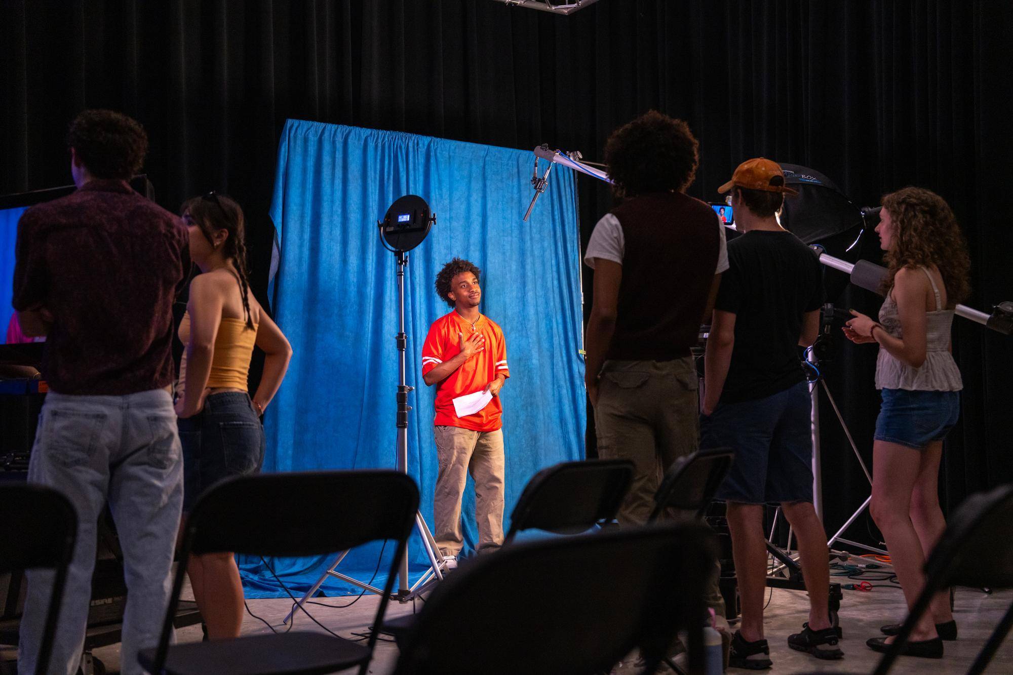 Student filming a performance in Live Oak Hall