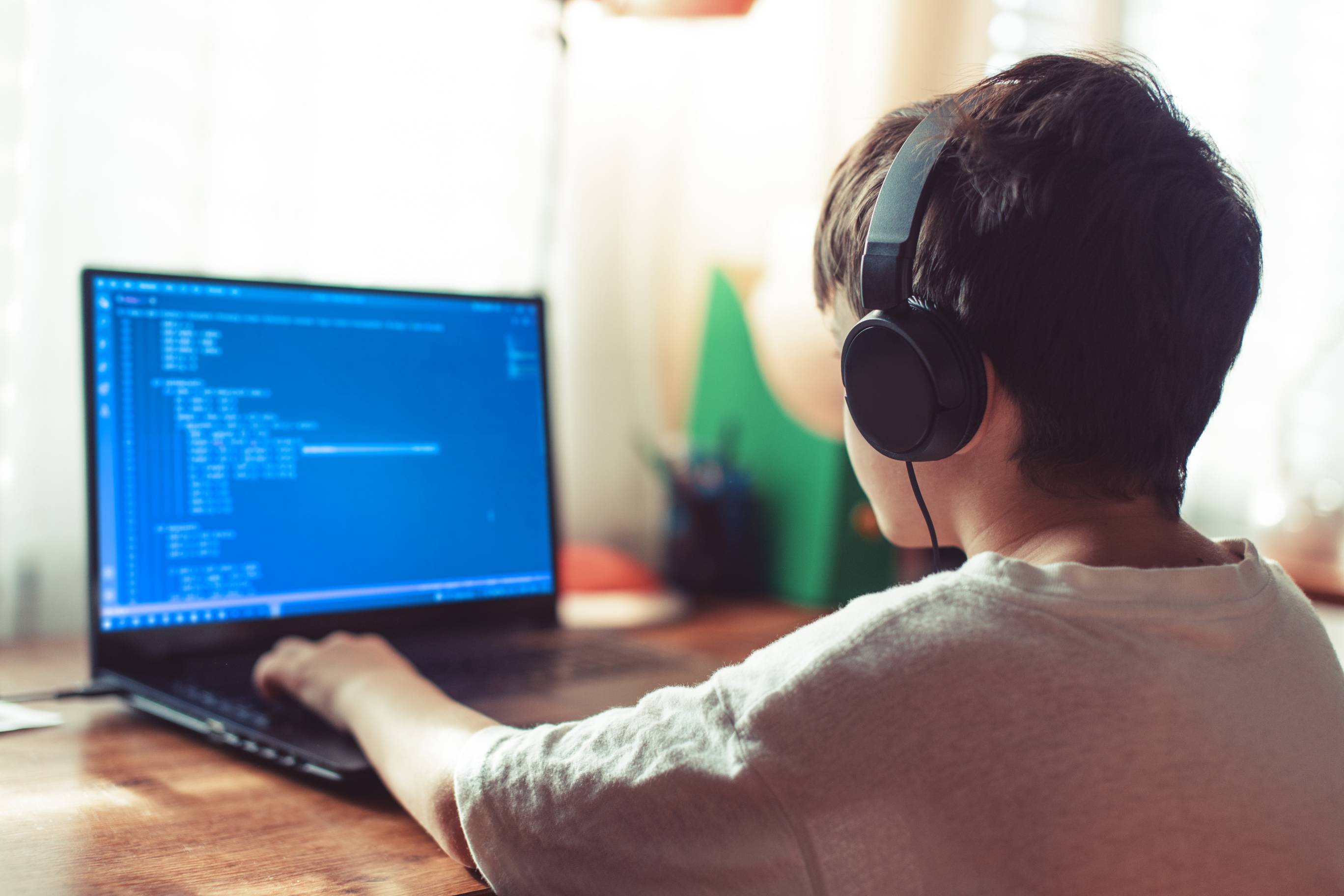 a young man with headphones on a laptop