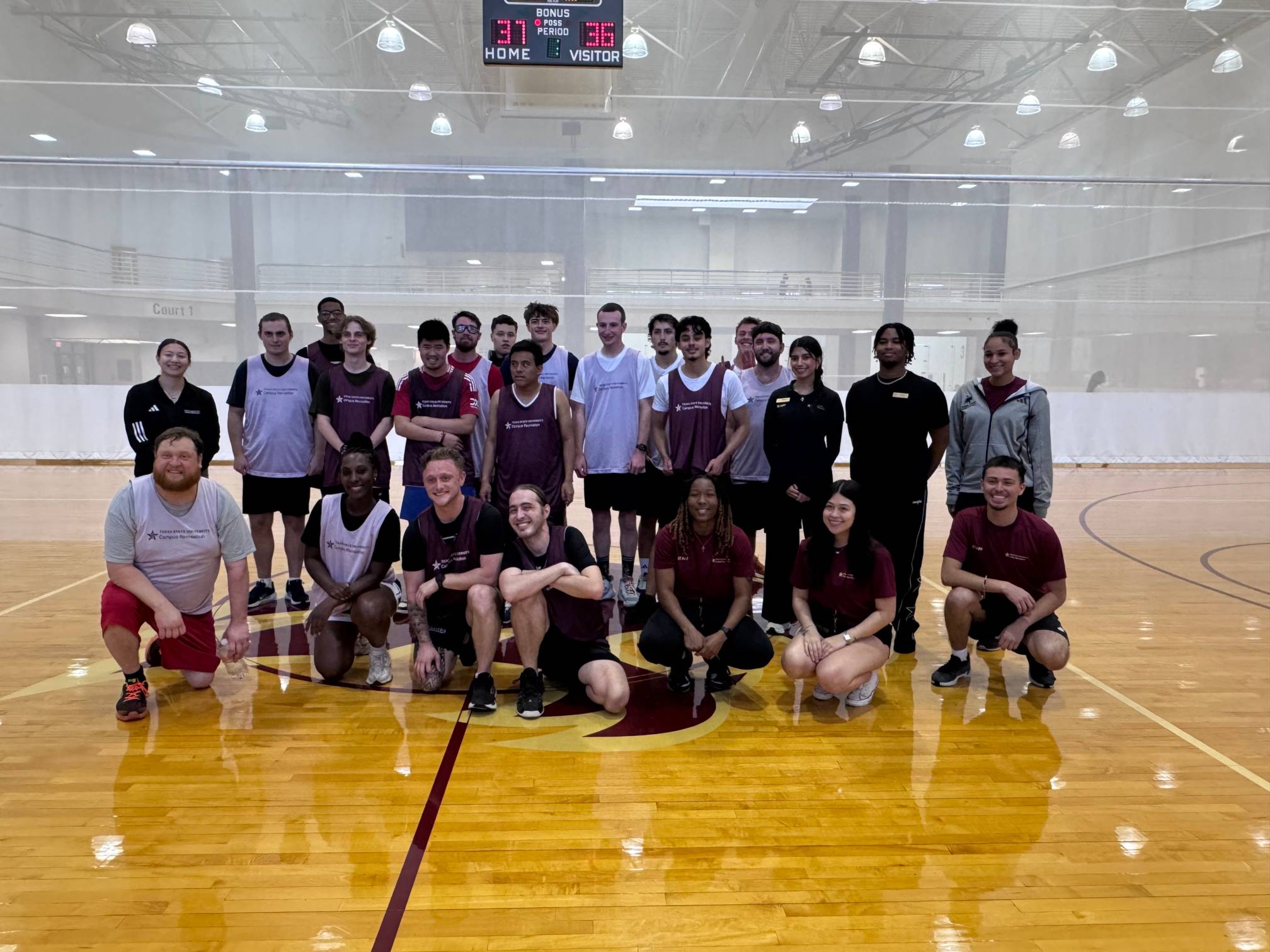 group photo of college students on an indoor basketball court