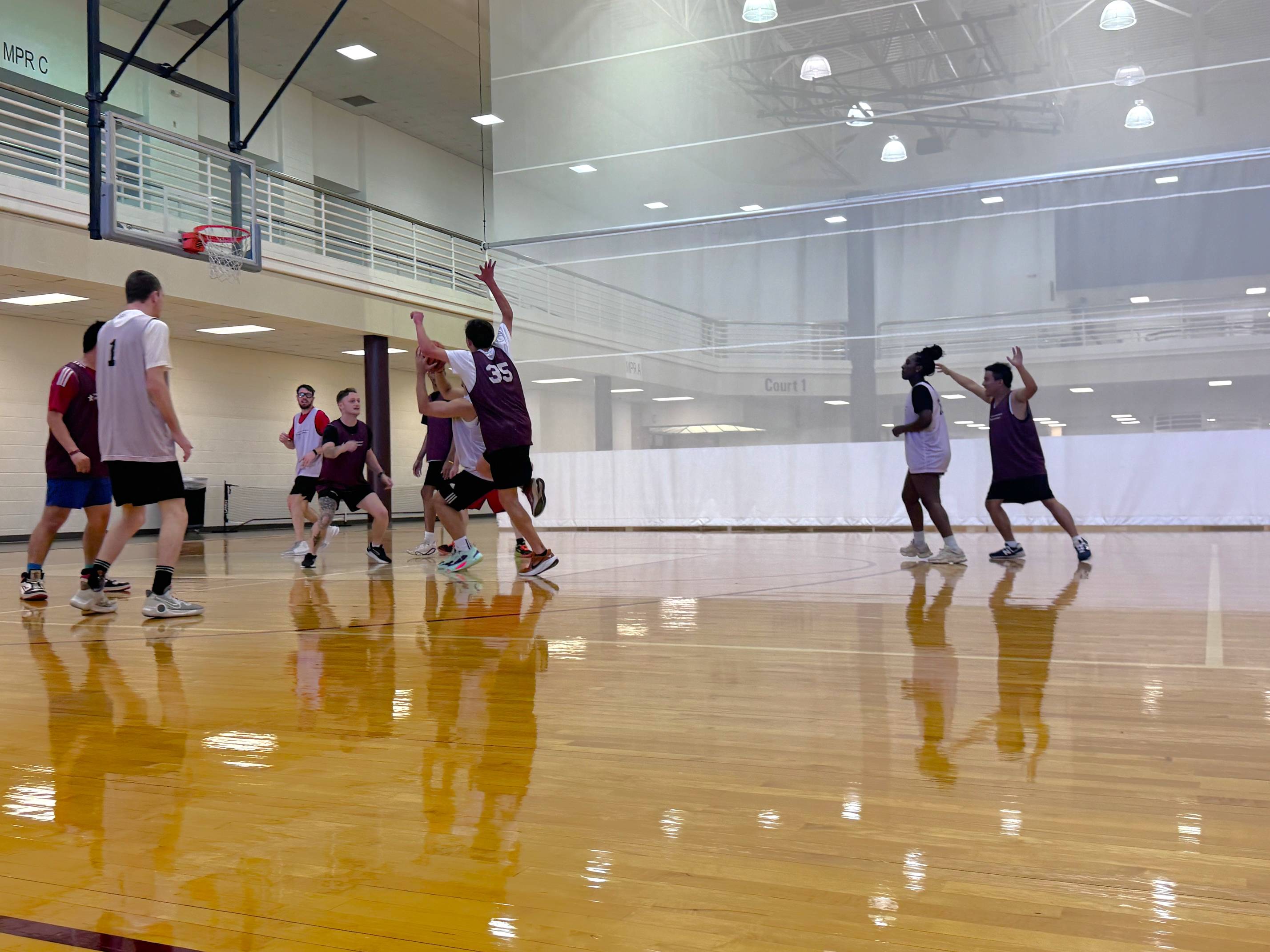 young men playing basketball on an indoor court