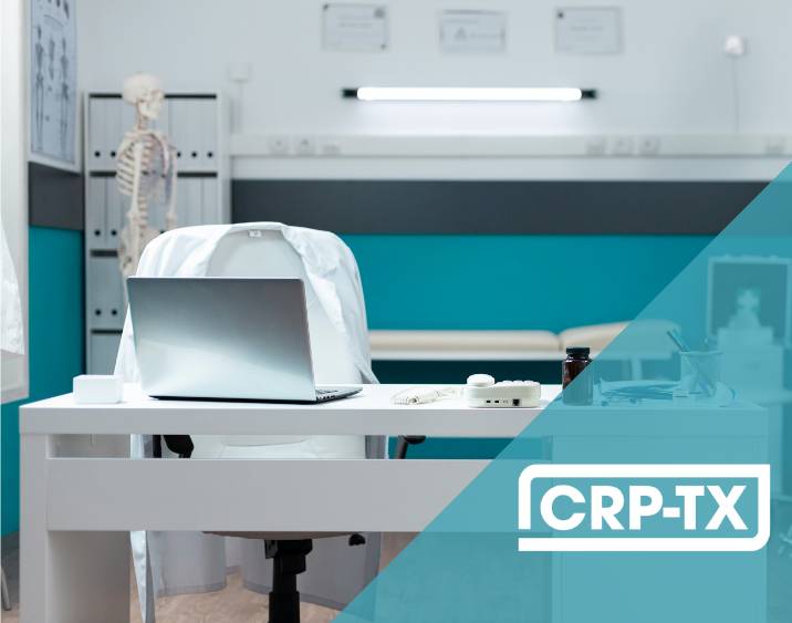 A laptop sits on a desk in front of a chair covered with a white lab coat. The setting  is in a hospital clinic. The CRP-TX logo appears in the corner.