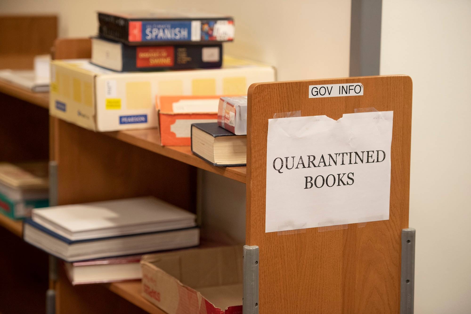 Bookshelf with sign reading "quarantined books"