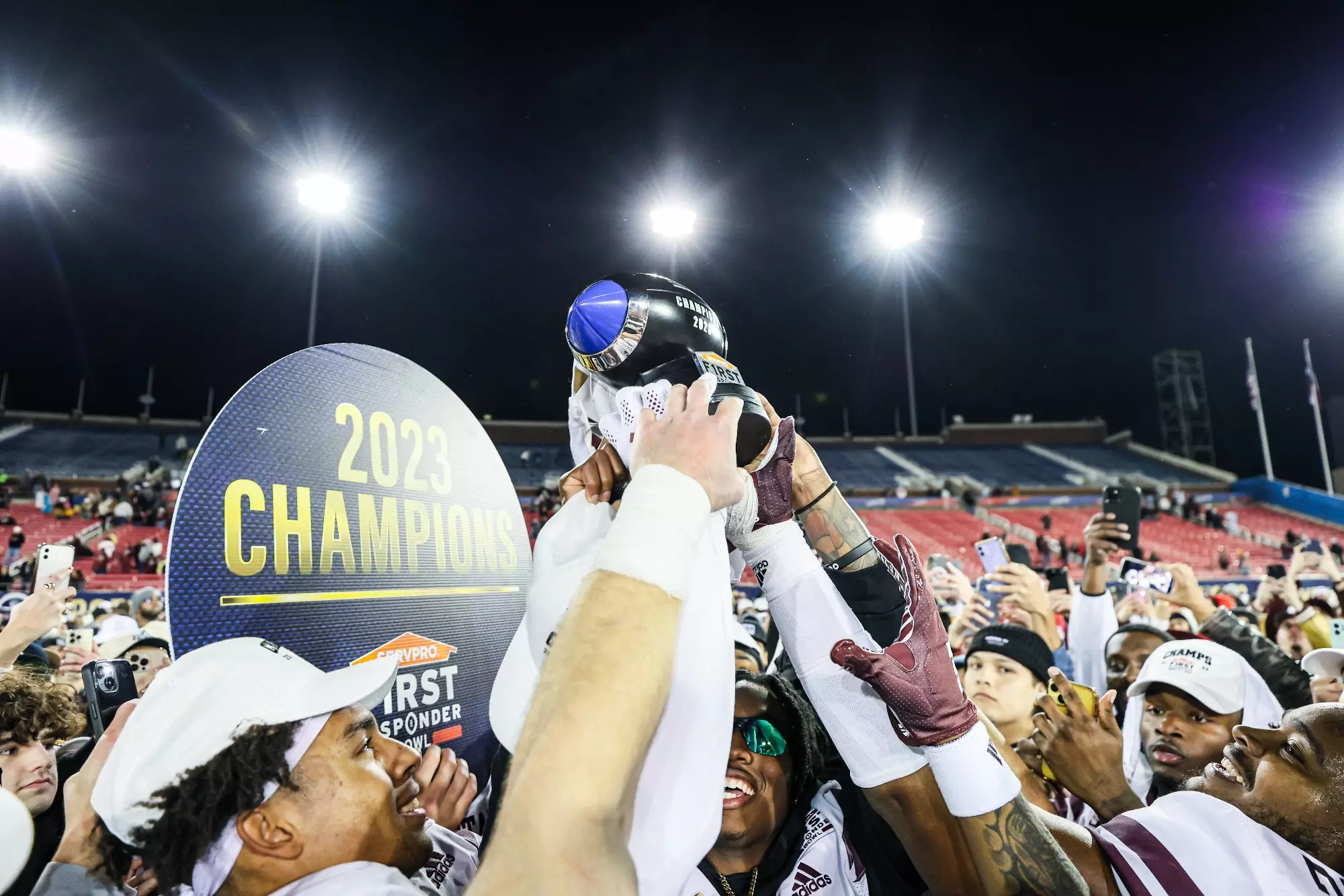 Football team holding Bowl Game Trophy