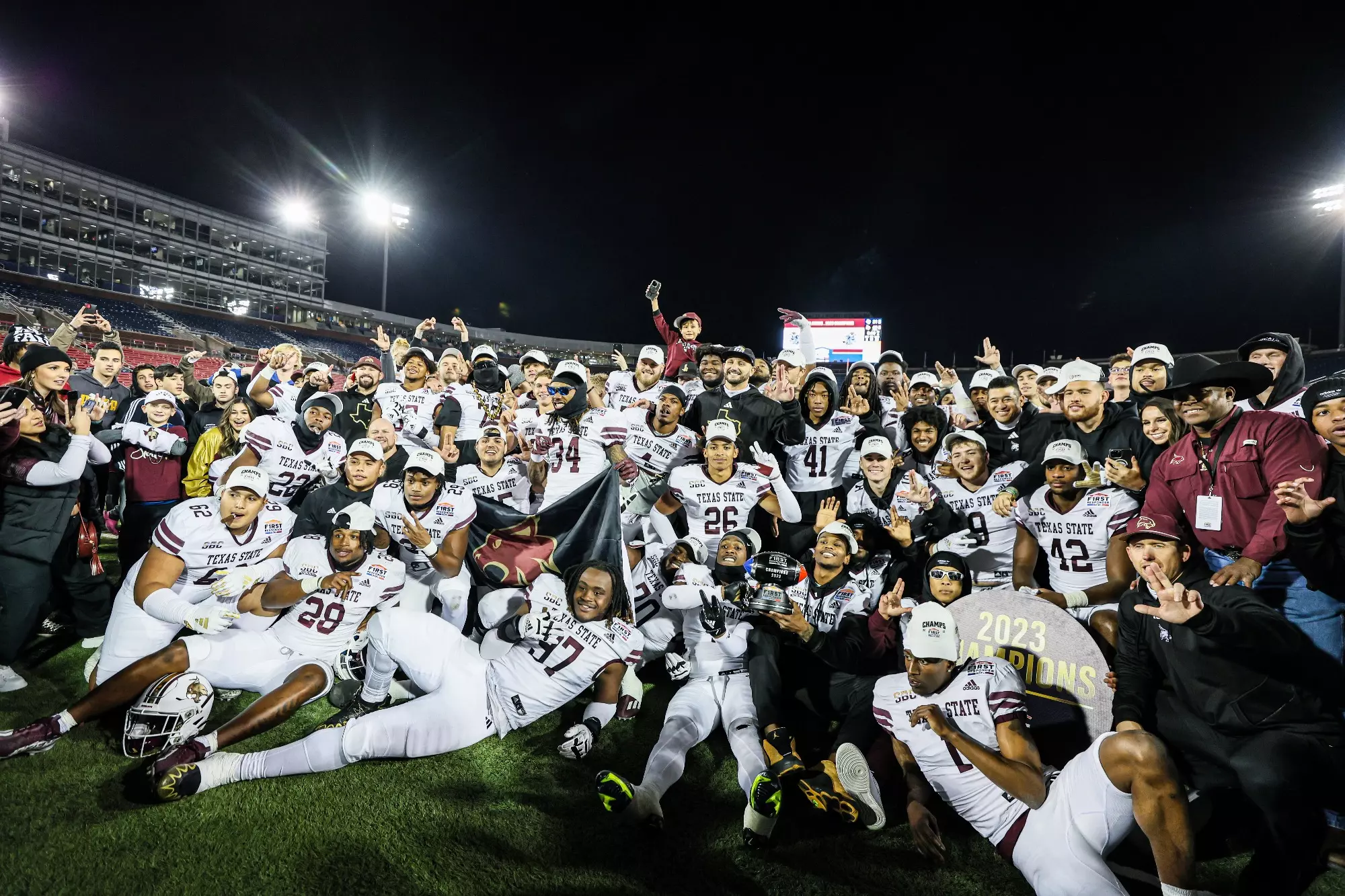 Football team posing for photo after bowl game win