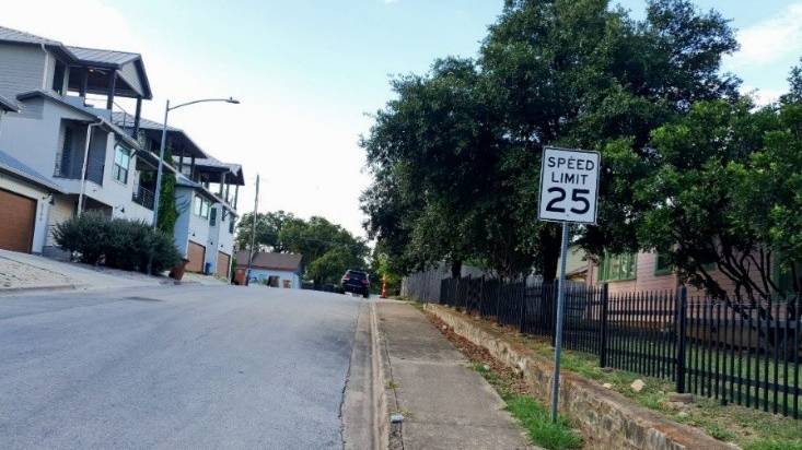 This image shows luxury townhomes on one side of the street and older, traditionally built houses on the other in East Austin, highlighting shifts in the neighborhood’s housing landscape. Photo by Hilary Ansah.