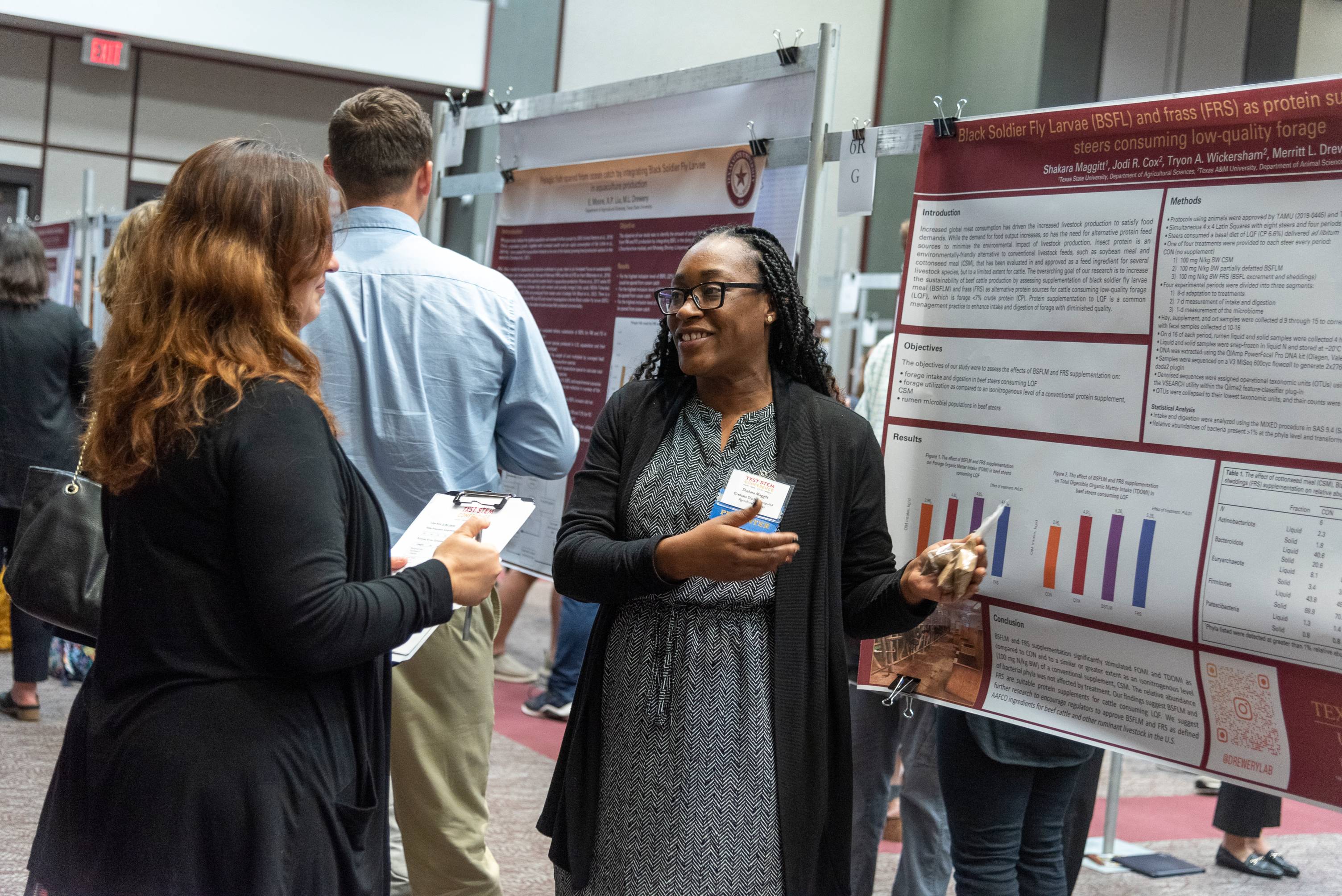 woman presenting research poster to another woman