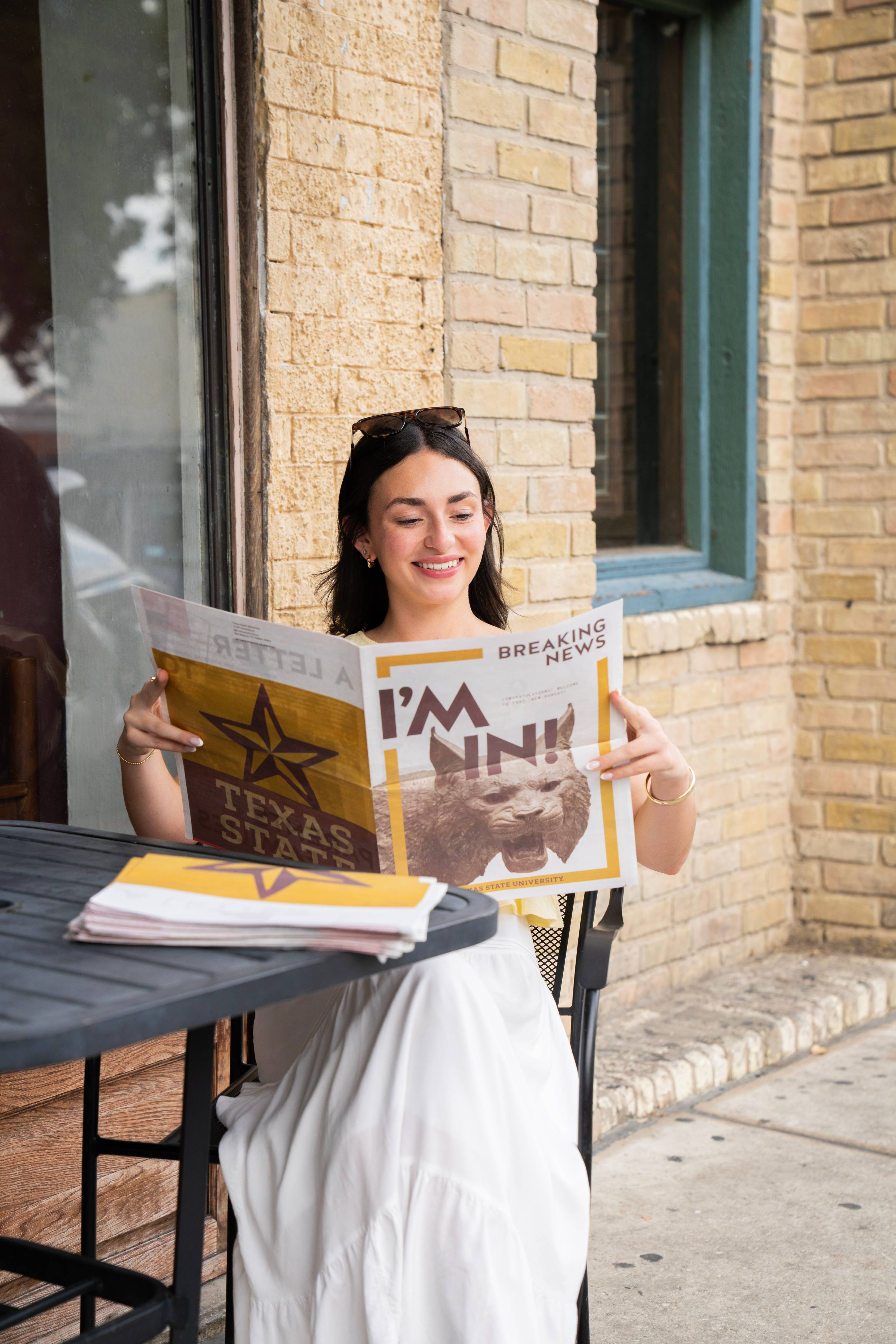woman sitting down reading a newspaper that reads "I'm in!"