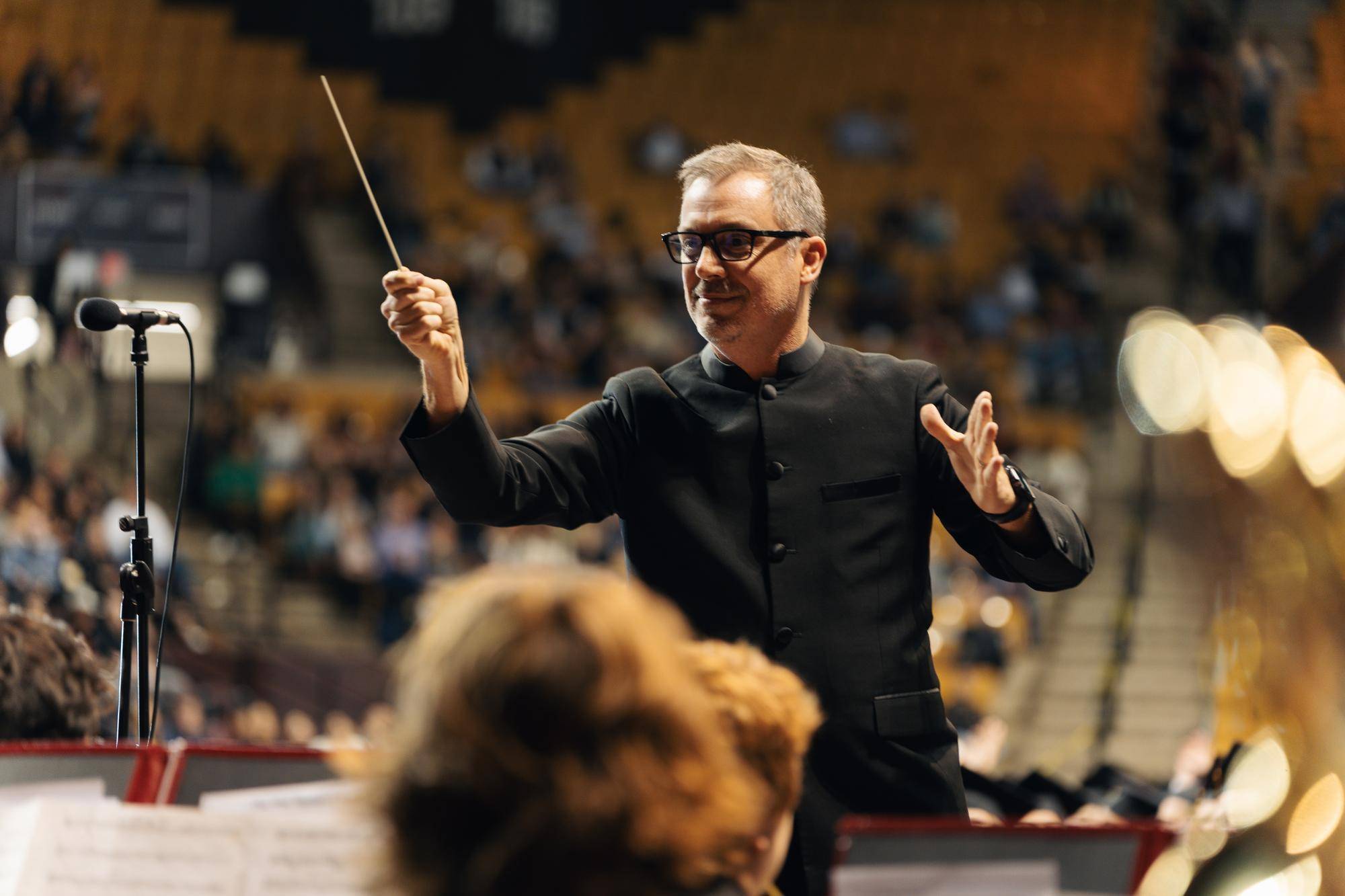 conductor directing orchestra in stadium