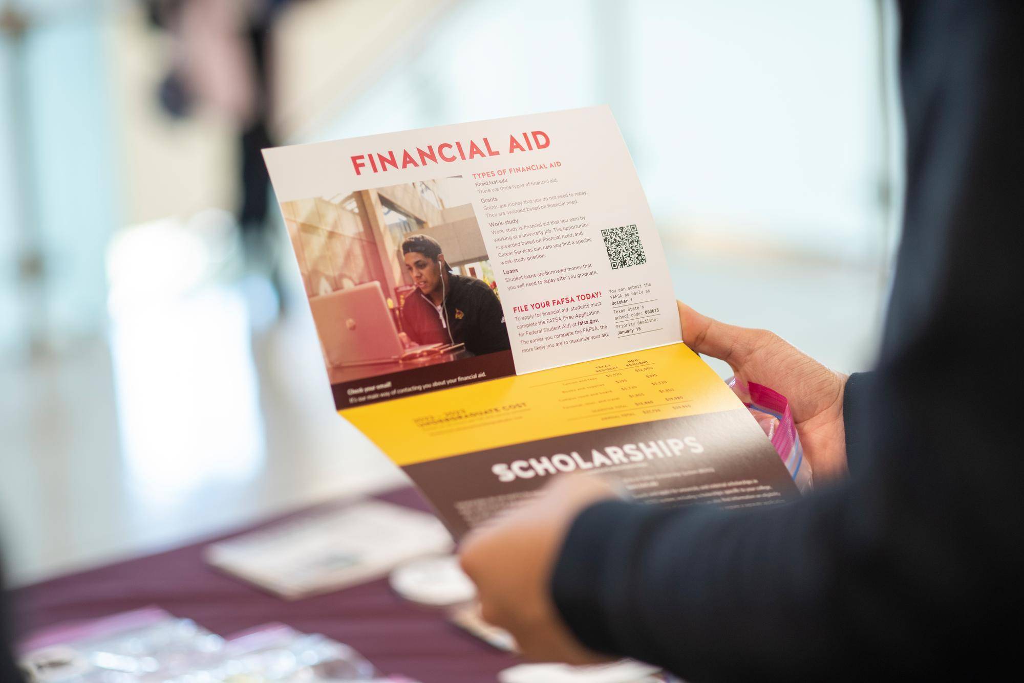 a flyer for financial aid in a person's hands