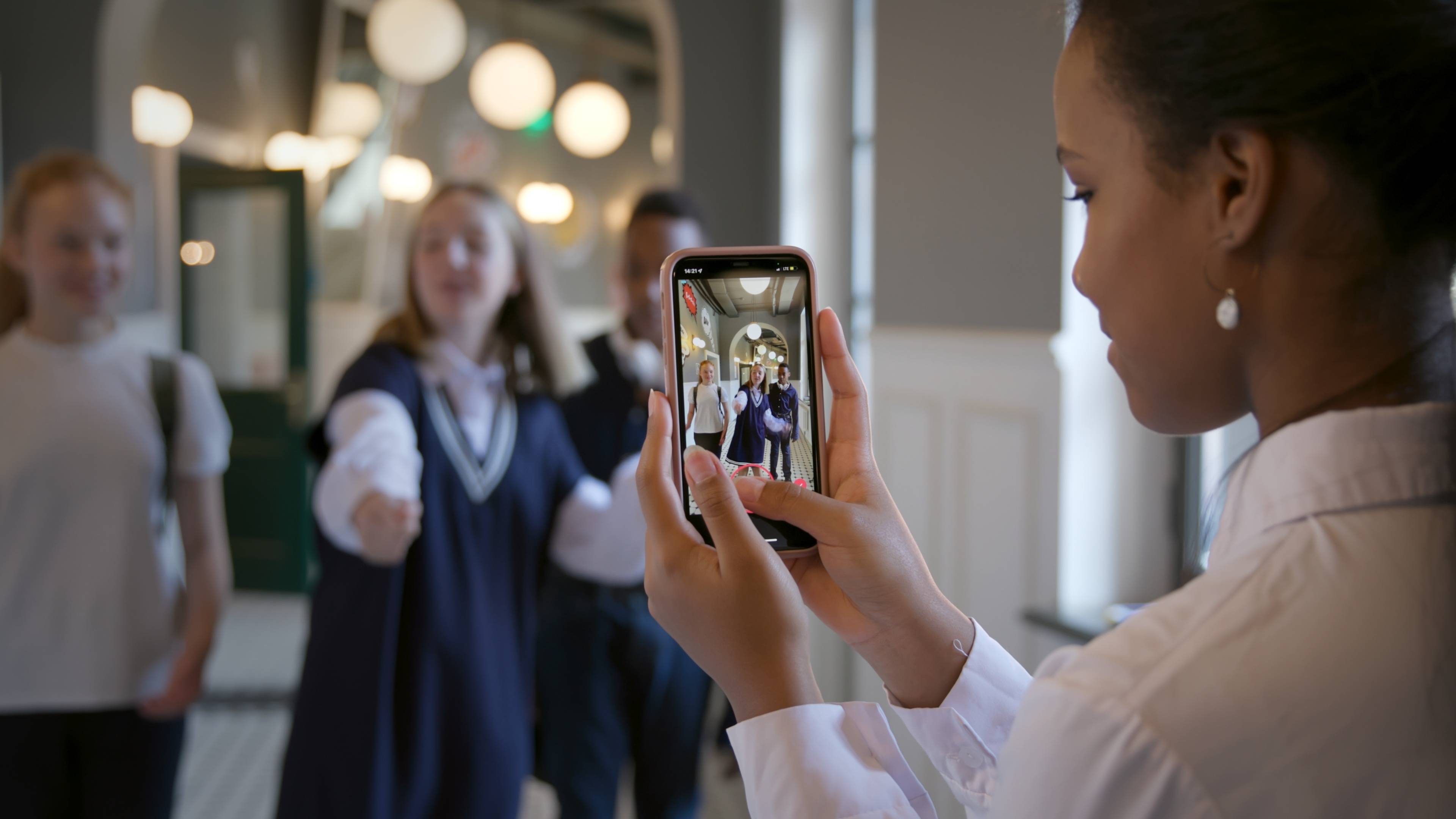 student using iphone to film other students