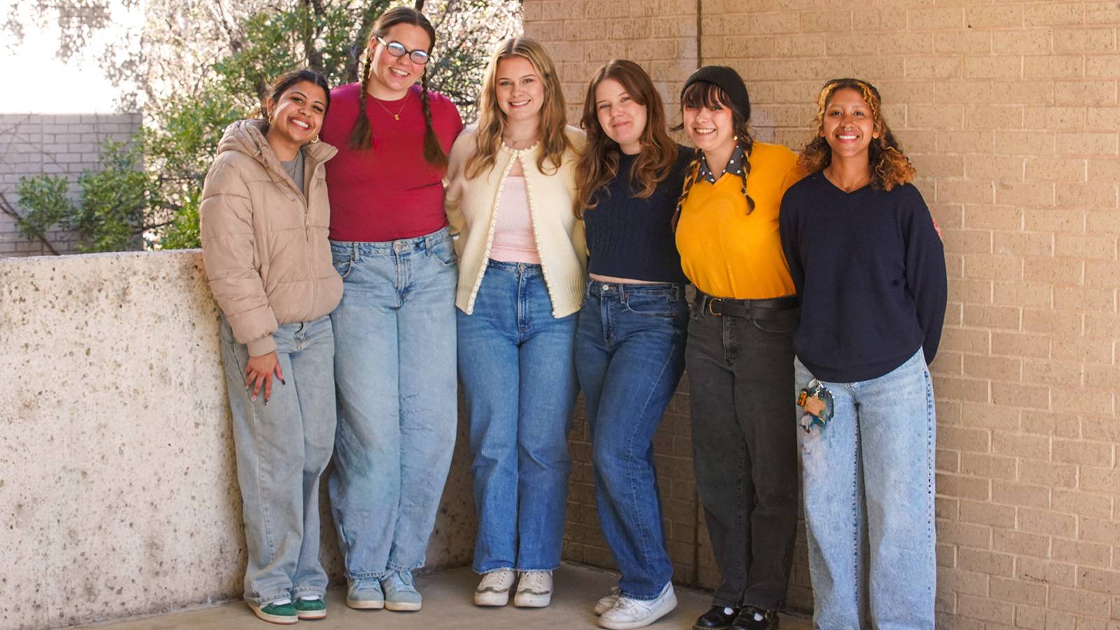 group of six Texas State students posing for photo on campus