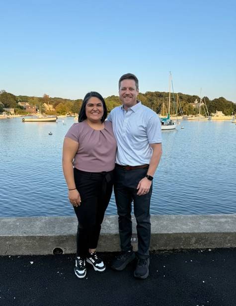 two people pose by water