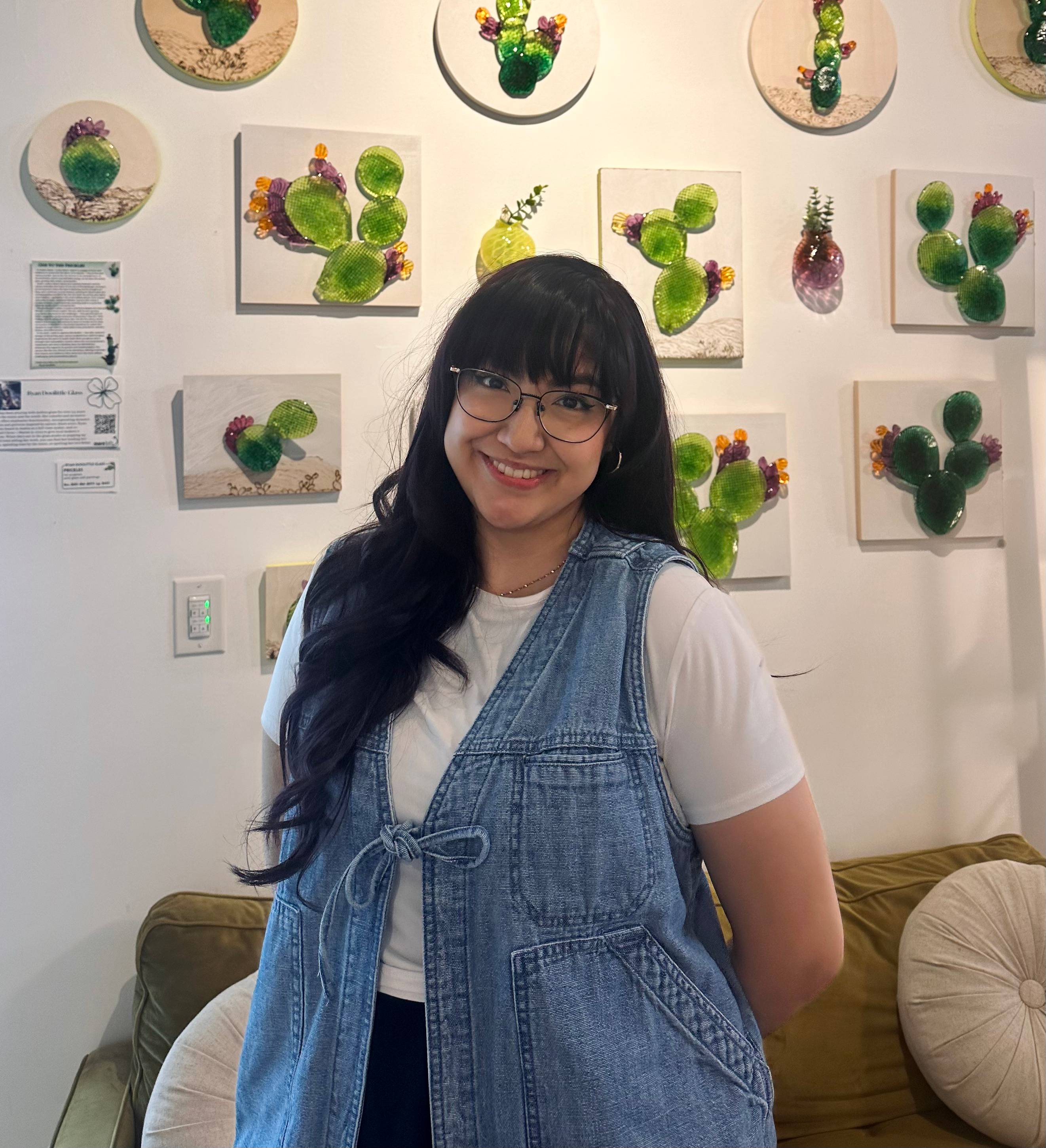 Ms. Flores standing in front of a background full of cactus