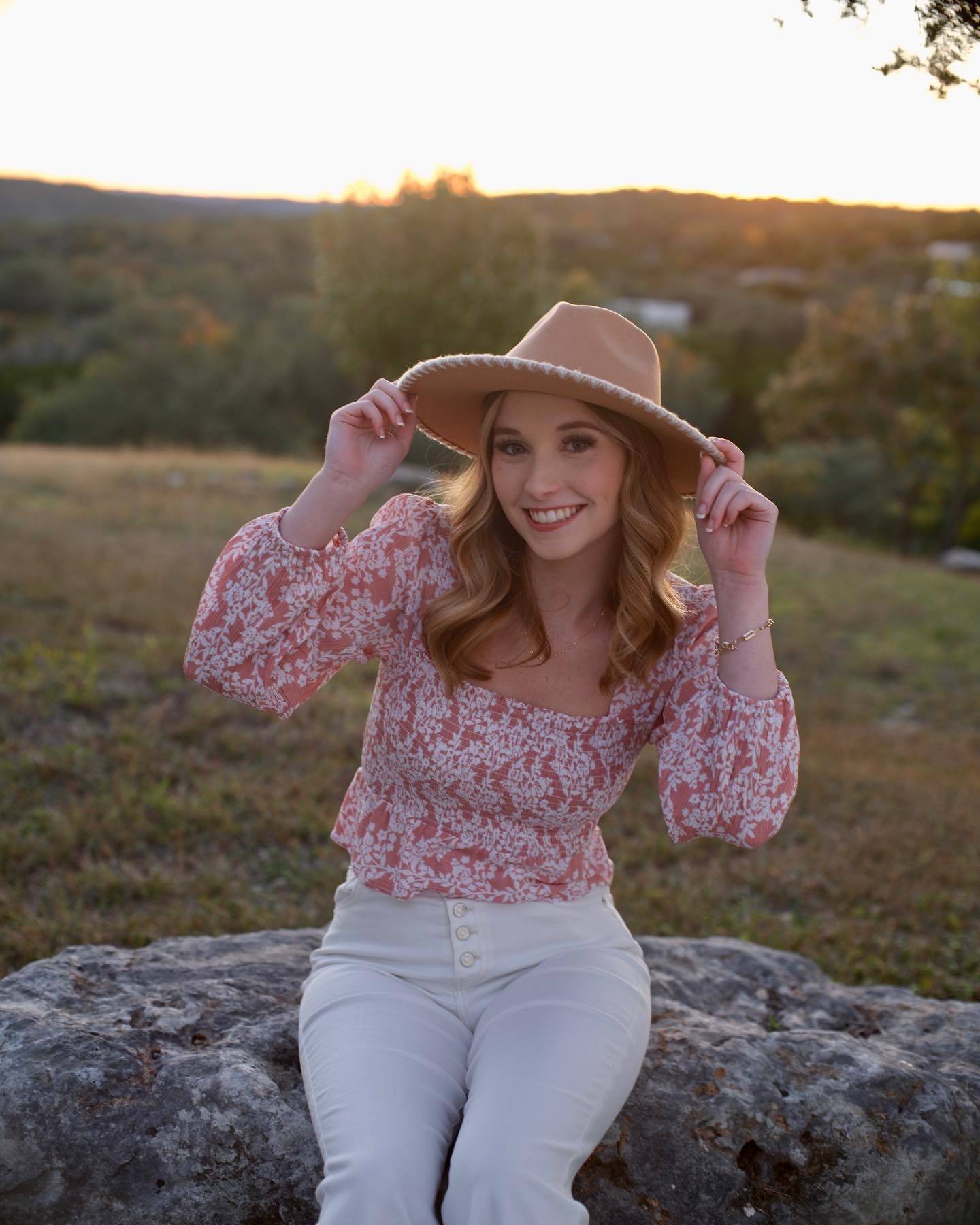 Ms. Thompson sitting on a rock
