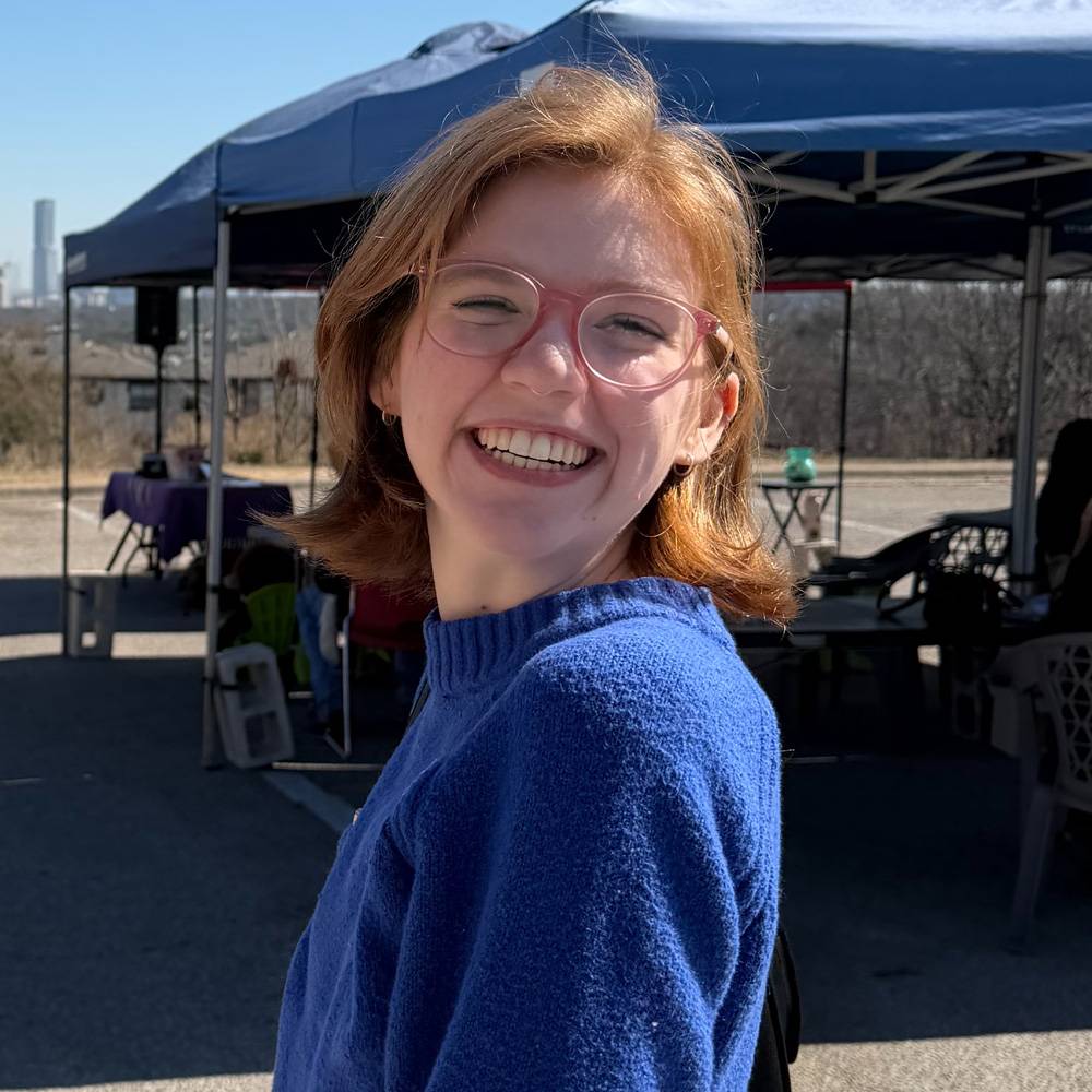 President of Sigma Tau Delta Sara Snyder A smiling girl with glasses wearing a blue sweater, exuding a cheerful and friendly demeanor.  