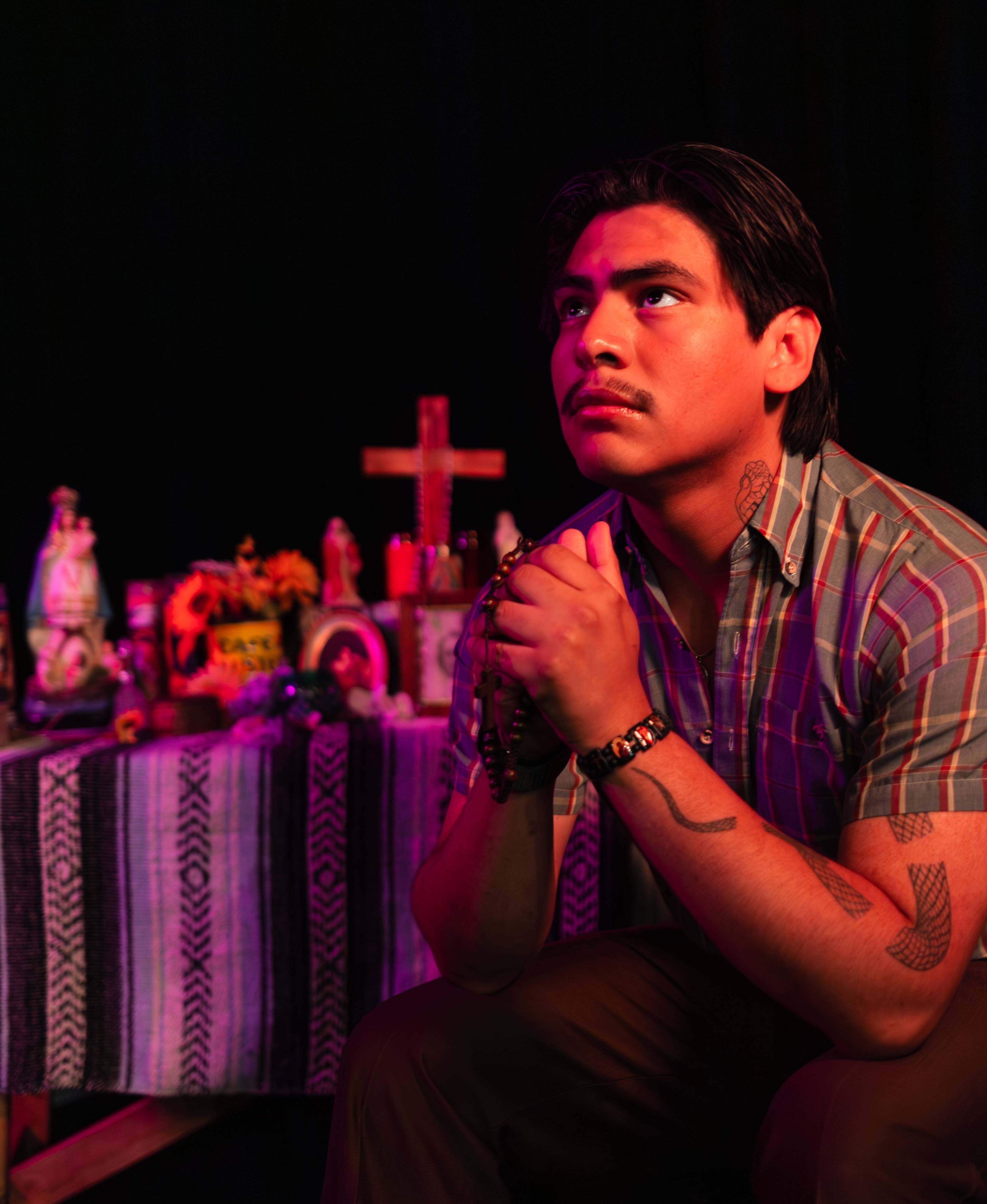 man praying in front of mexican altar