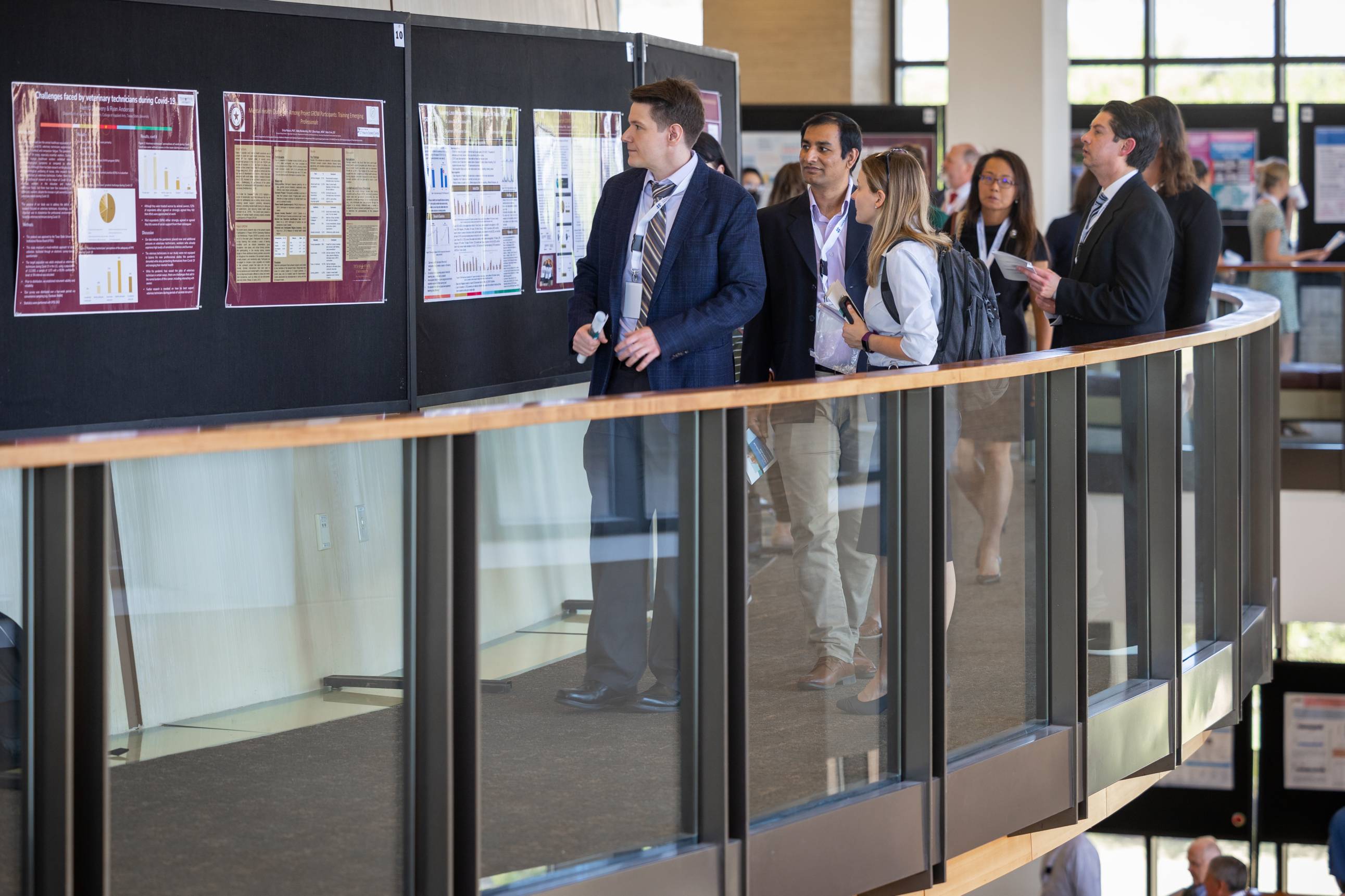 researchers looking at presentation posters at a conference