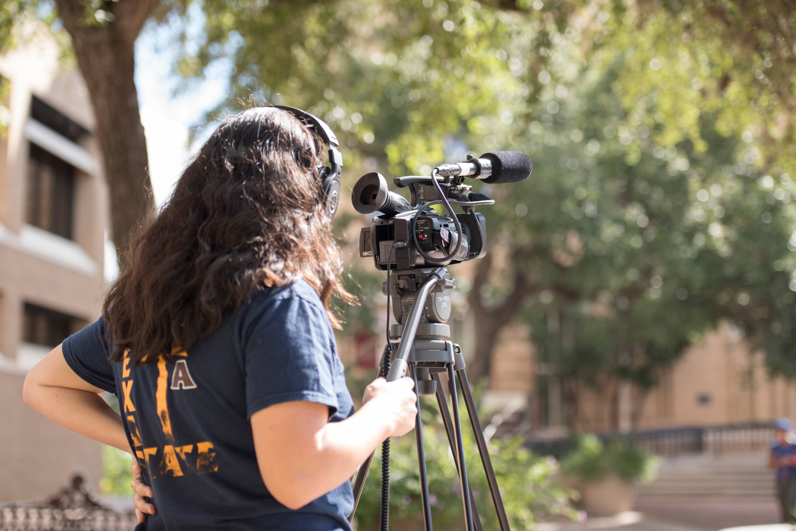 a student films with a camera and tripod