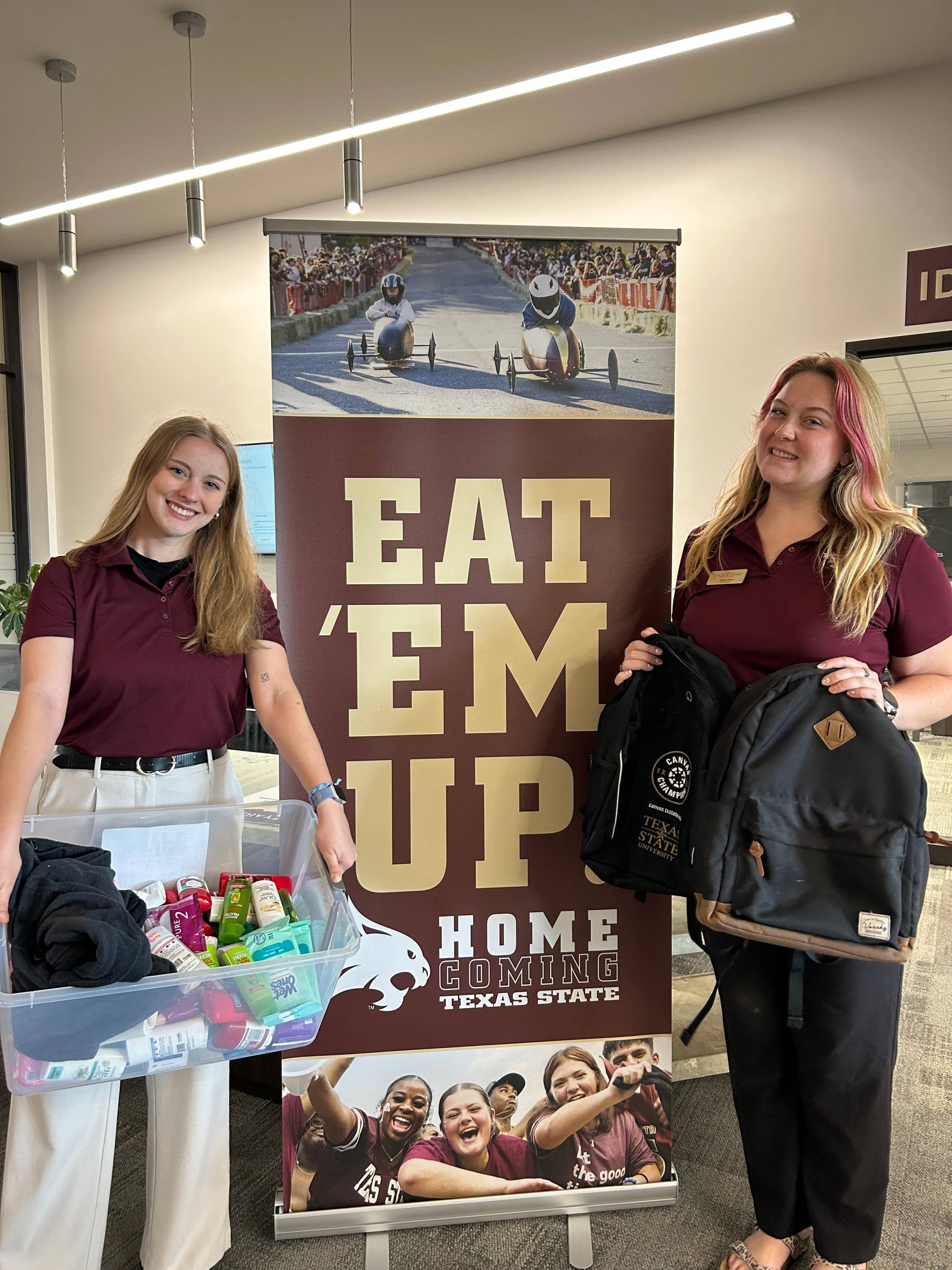 Two McCoy Ambassadors holding donations for the Homecoming Donation Drive